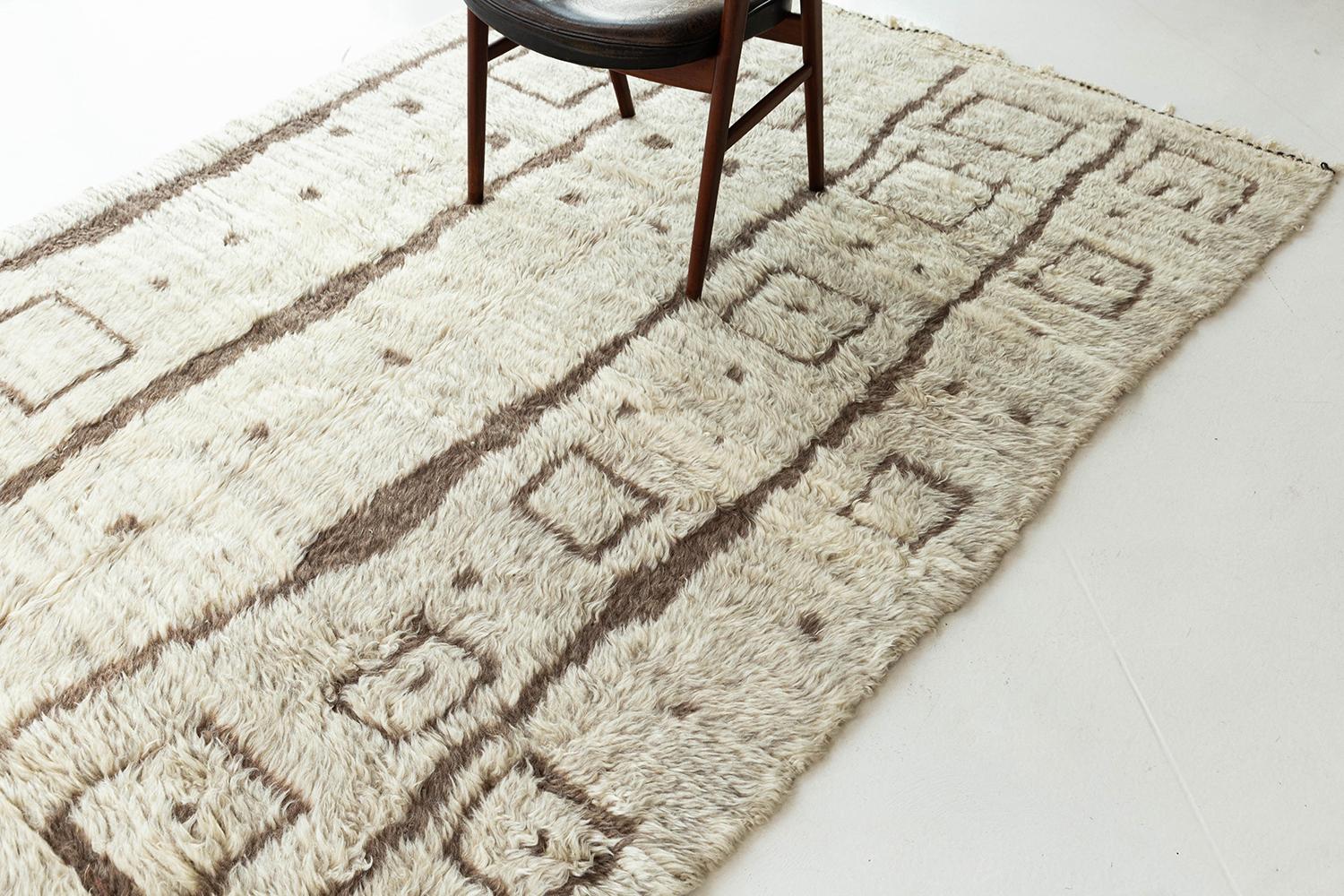 A beautiful Beni Ourain tribal Moroccan rug that exudes sophistication and charm. A ivory pile weave adorned with taupe tribal elements makes for the perfect contemporary. This handwoven wool piece brings an exciting essence to any design space.