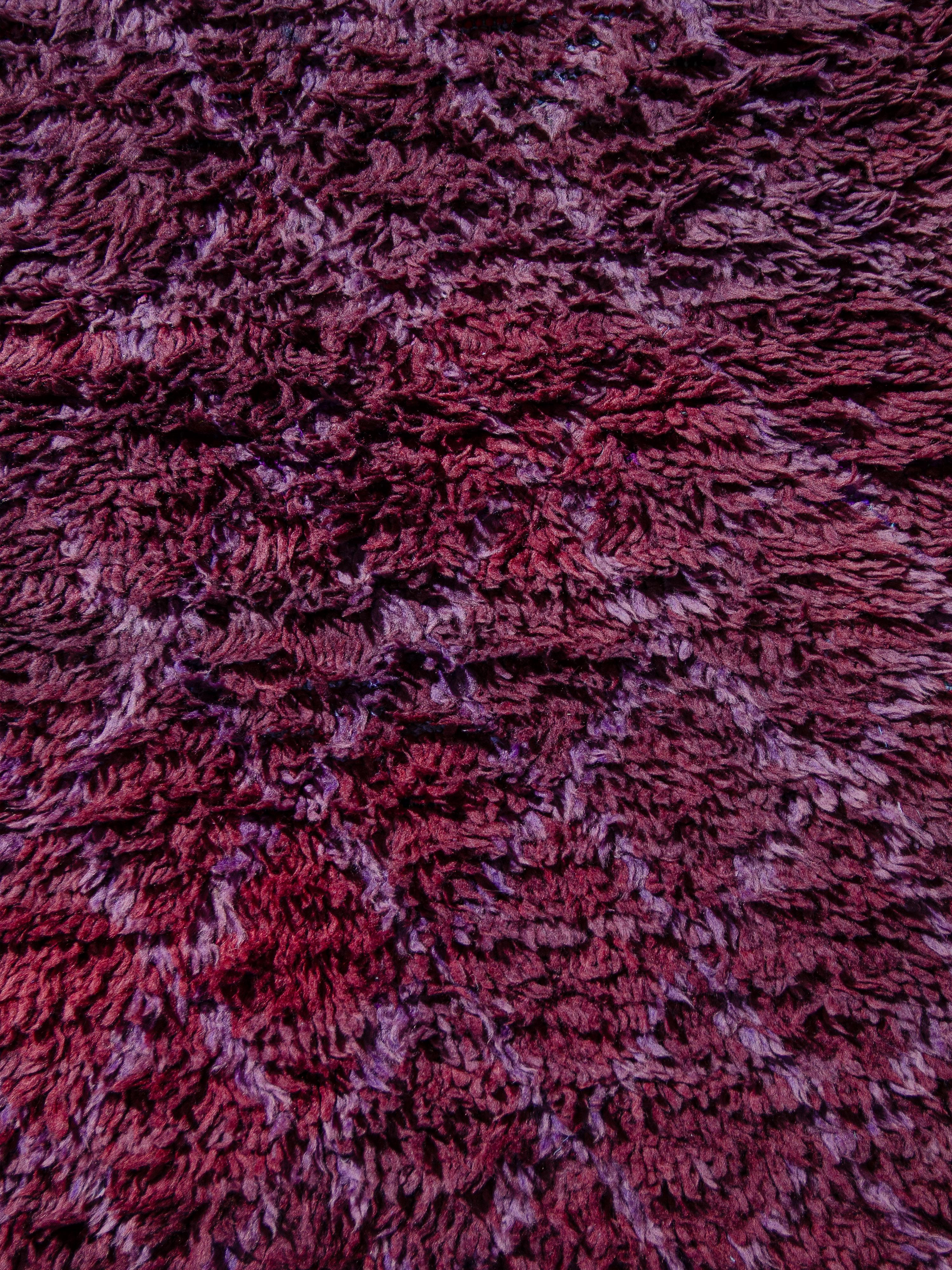 Un coureur minimaliste de Beni M'Guild avec un champ magenta abrasé contenant un réseau classique de losanges féminins noués dans une lavande contrastante plus claire. Le poil dense entièrement en laine présente un toucher dense. Une taille de