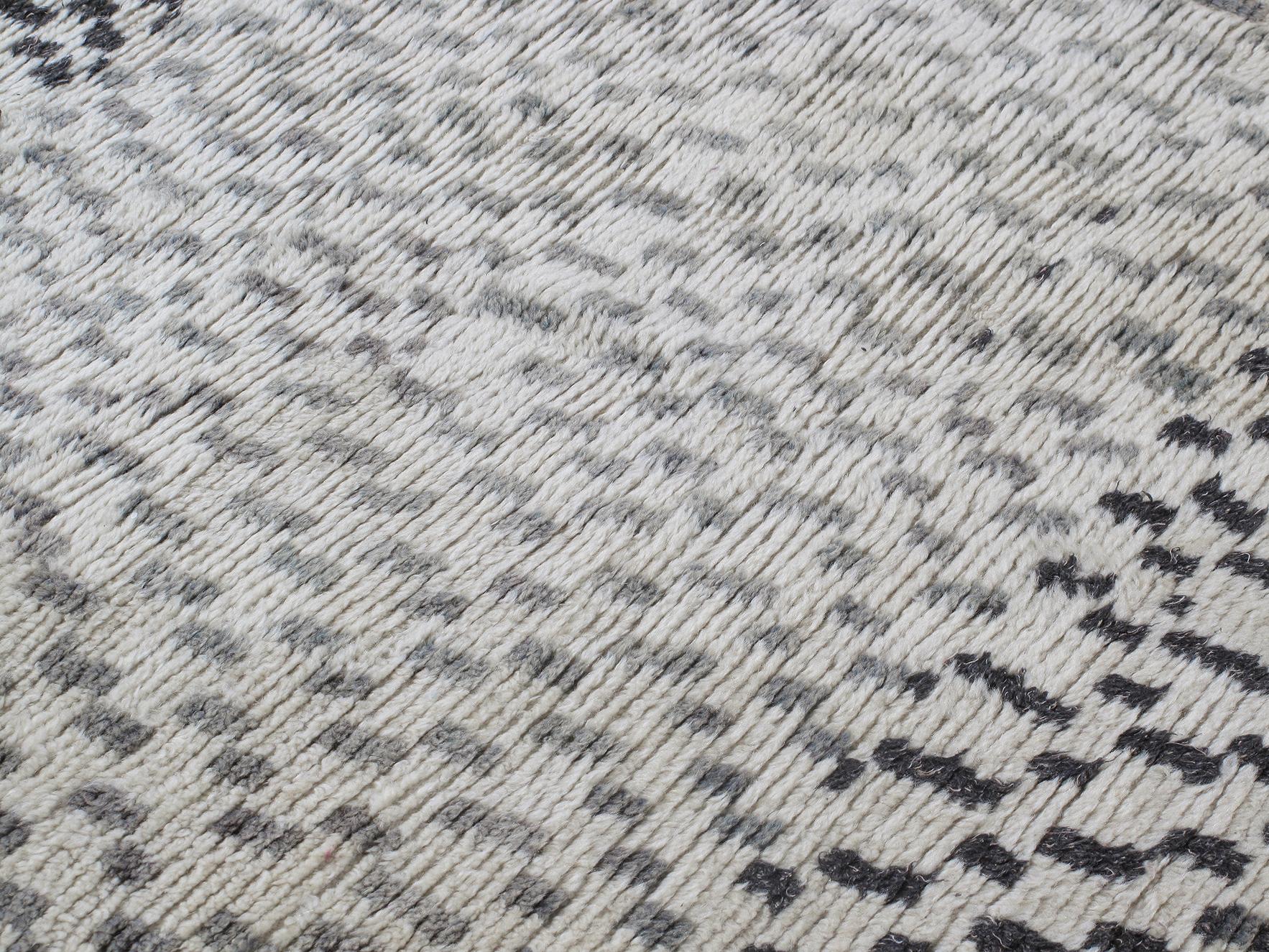 Vintage Moroccan Berber hand-knotted wool rug is hand-carded with all natural dyes in beige, black and grey colors. Selectively curated from thousands of pieces, our Moroccan Collection represents the most unique styles from the Atlas Mountain
