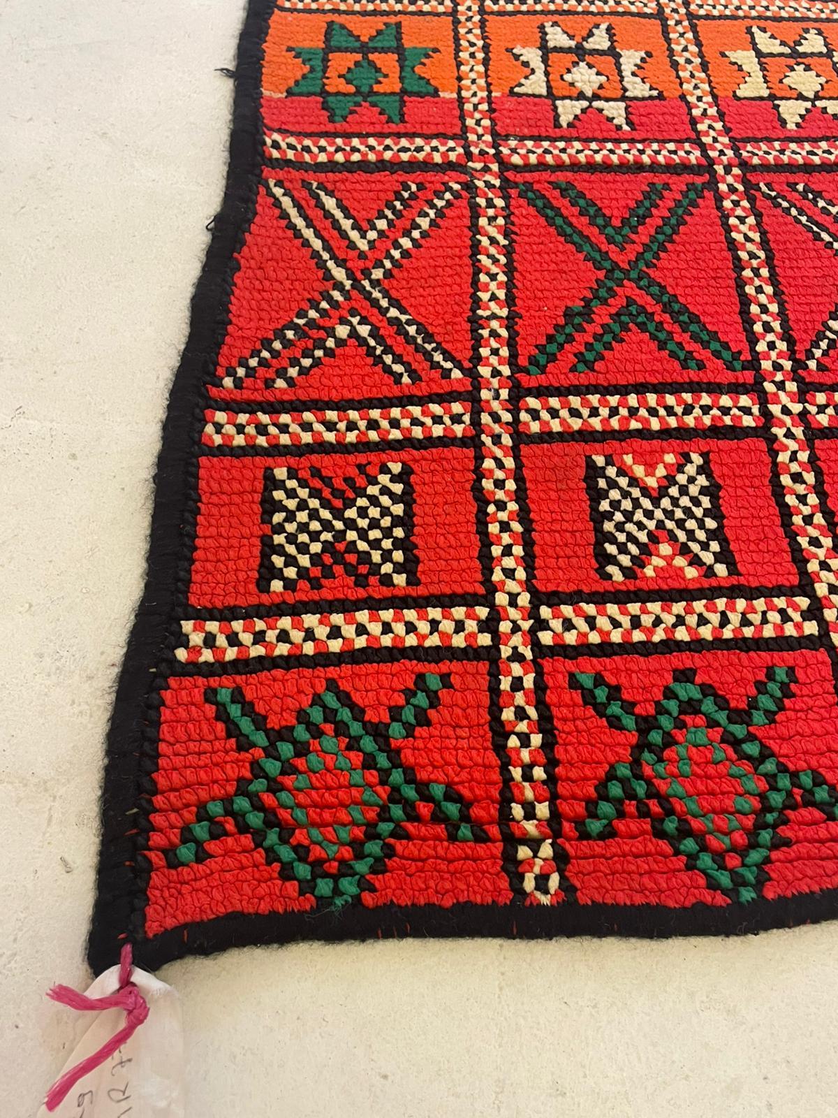 A striking vintage Berber kilim rug from the Middle Atlas region of Morocco, handwoven by Amazigh (Berber) artisans in the 1950's-19'60's. This flatweave textile features a dynamic interplay of geometric tribal motifs arranged in structured rows,