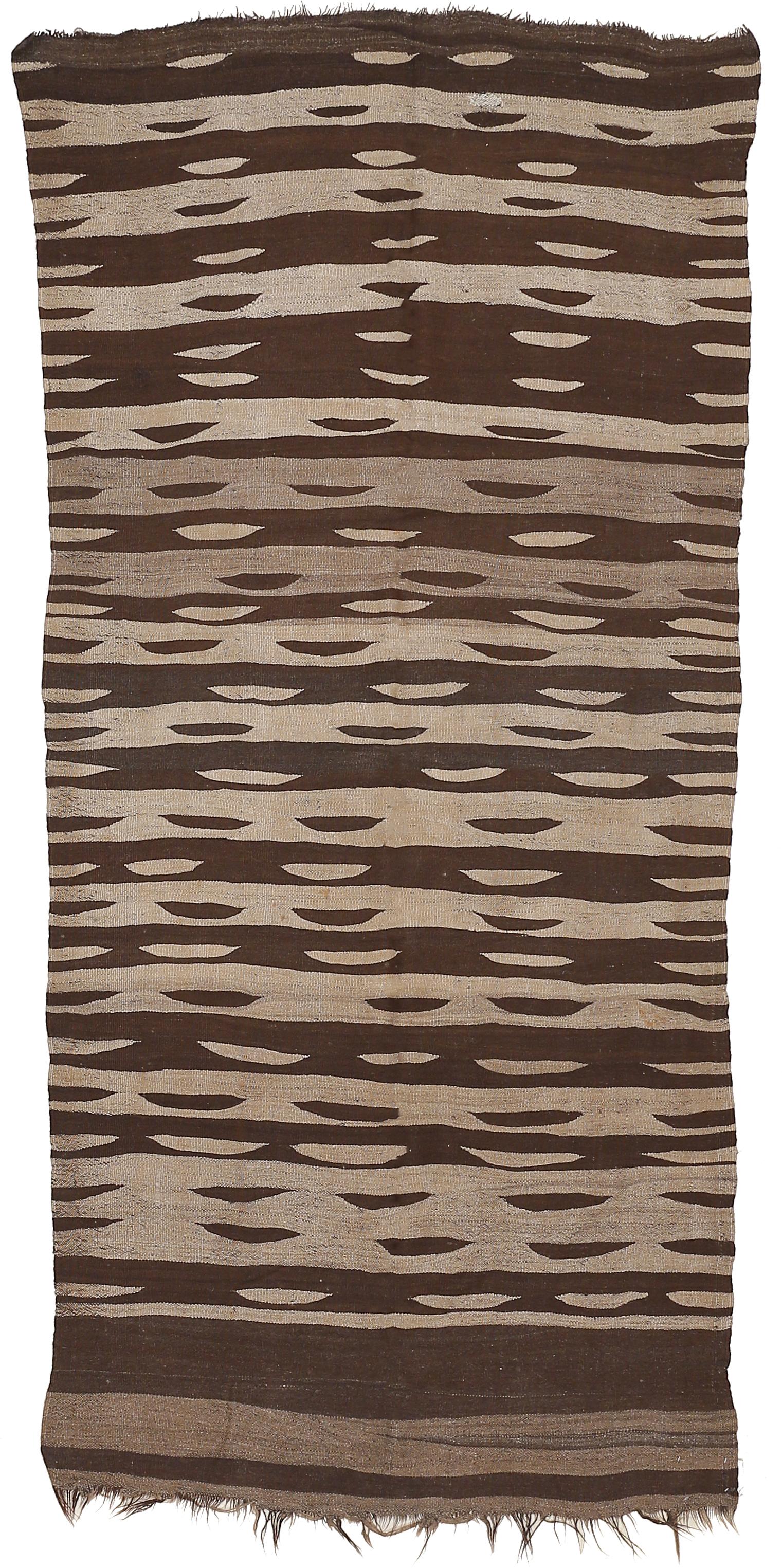 A rare and beautiful flat-weave from the Ourika valley, located in the Moroccan High Atlas, distinguished by a mocha palette obtained from natural, undyed wools, and by a repeat pattern of 'eyes' in contrasting colors.