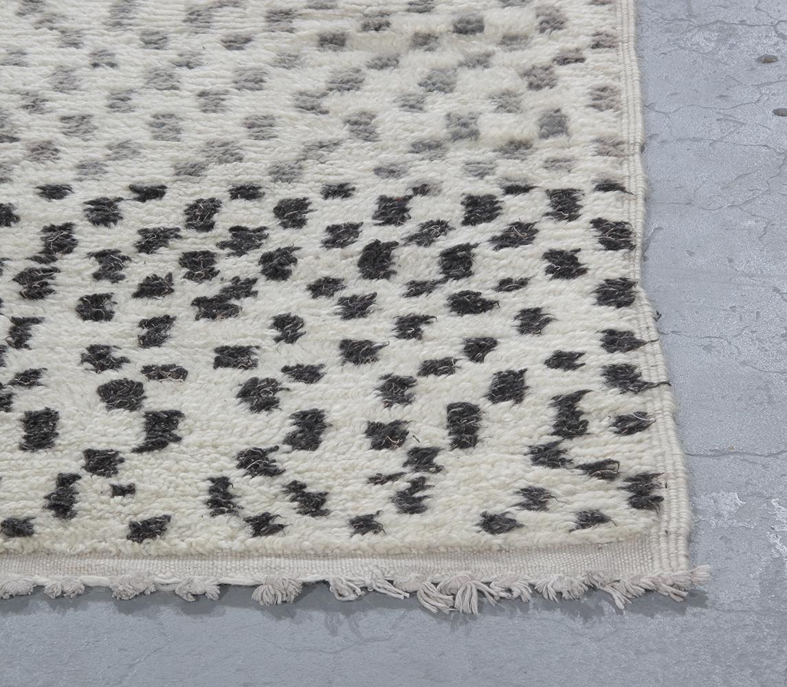 Vintage Moroccan Berber hand-knotted wool rug is hand-carded with all natural dyes in beige, black and grey colors. Selectively curated from thousands of pieces, our Moroccan Collection represents the most unique styles from the Atlas Mountain