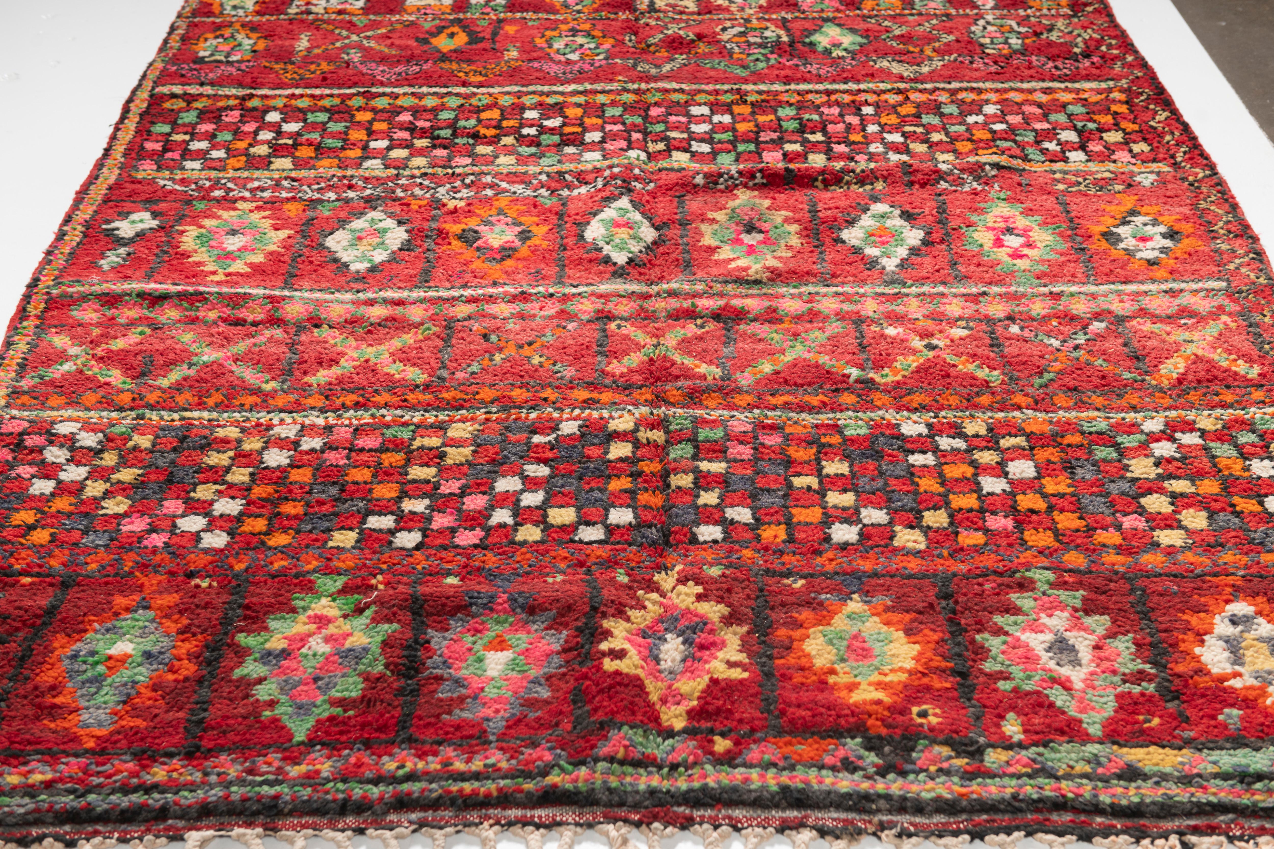 Vintage Moroccan Berber Zemmour Rug, 1920-1930s in deep red, orange, green, yellow, black and white, incorporating traditional geometric motifs in this hand-knotted, hand-spun sheep wool rug. Thick and shaggy pile make this a beautiful grounding