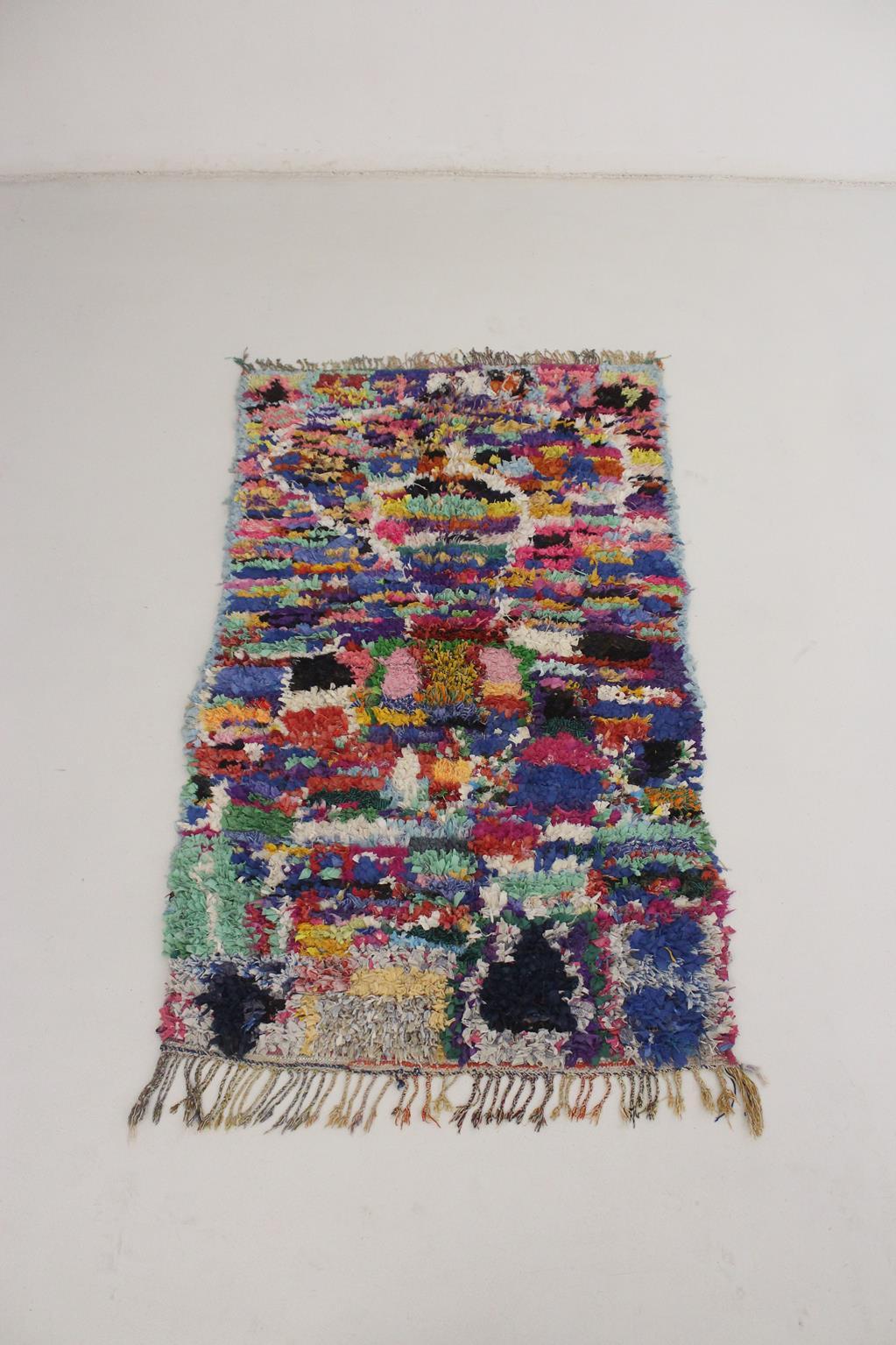 This vintage Boucherouite rug is made of multiple, colorful recycled pieces of clothes knotted on a cotton base. Women in Morocco have been using this technique for generations to recycle the family clothes cutting them in tiny, colorful pieces of