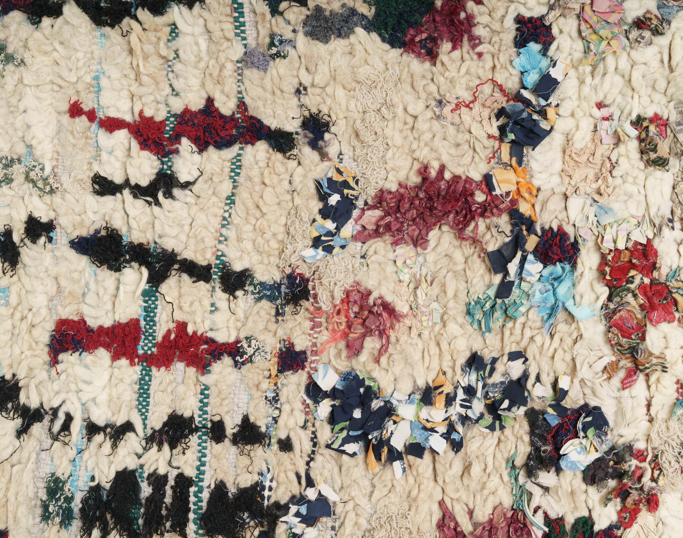 Colorful Moroccan Berber rug from the Boujaad tribe that originates from middle Morocco. Red, black, blue brown and green tones on natural white background. Medium-thick pile.

This is an authentic Berber carpet from Morocco. In Berber tribes rugs