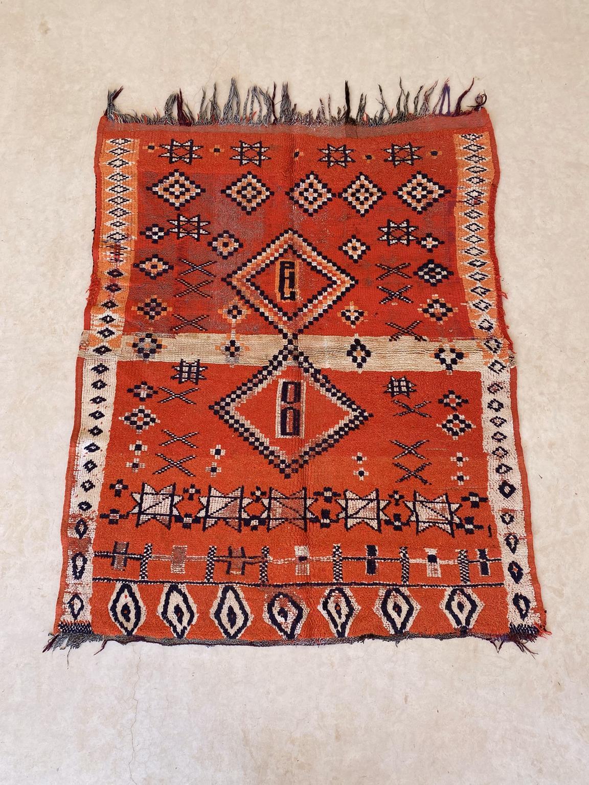 Wie schön ist das hier!! Dieser kleine Teppich wurde wahrscheinlich in der Gegend von Boujad, Mittlerer Atlas, Marokko, hergestellt. Die Hauptfarbe ist ein leuchtendes Rot, und der Teppich scheint in zwei gleiche Teile geteilt zu sein, die durch