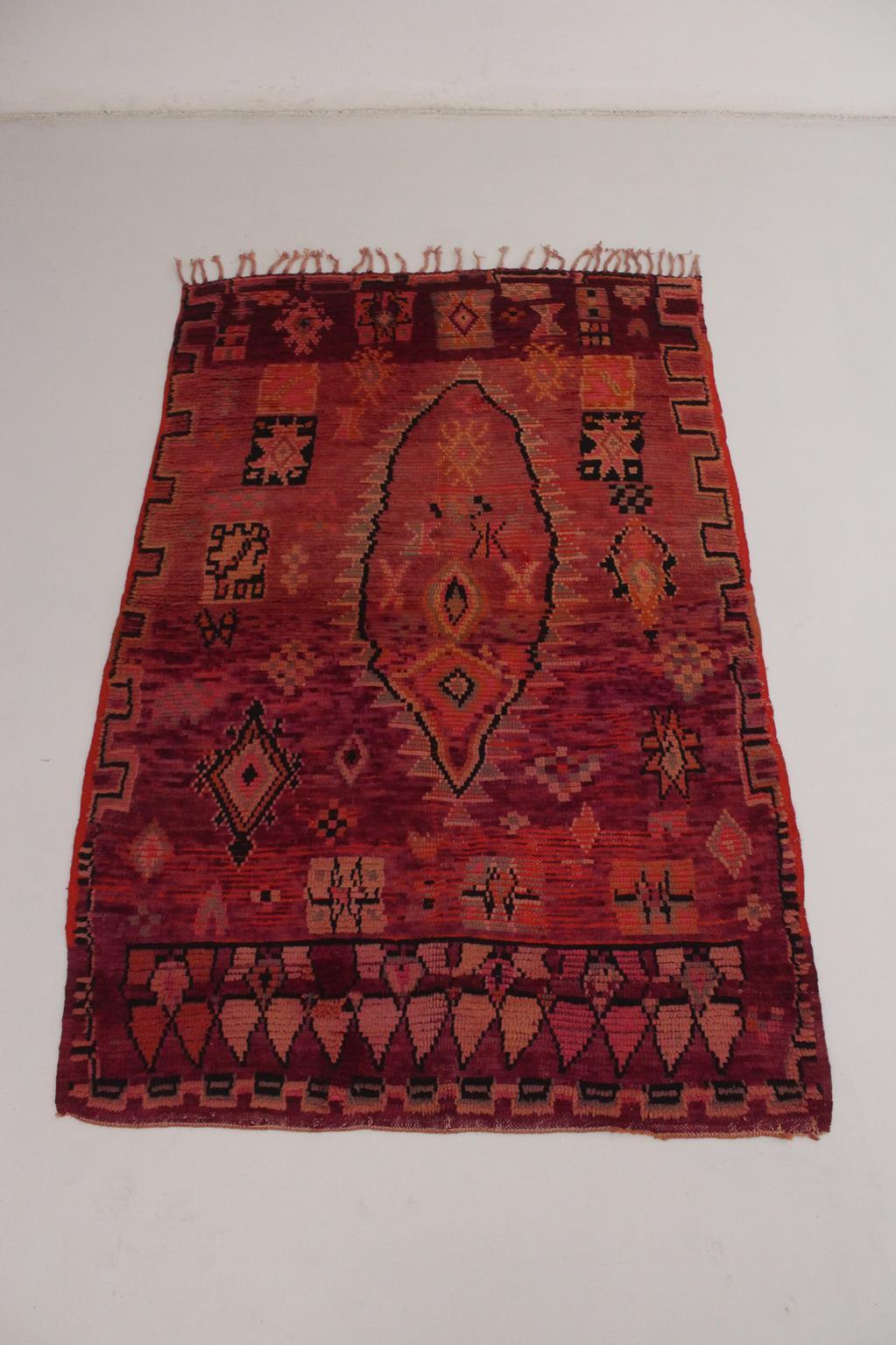 This beautiful vintage Boujad rug is a collector rug! It shows bright colors and a great composition made of traditional designs like diamonds, stars and crosses surrounding the main feminine design in the middle. The whole rug is so vibrant with