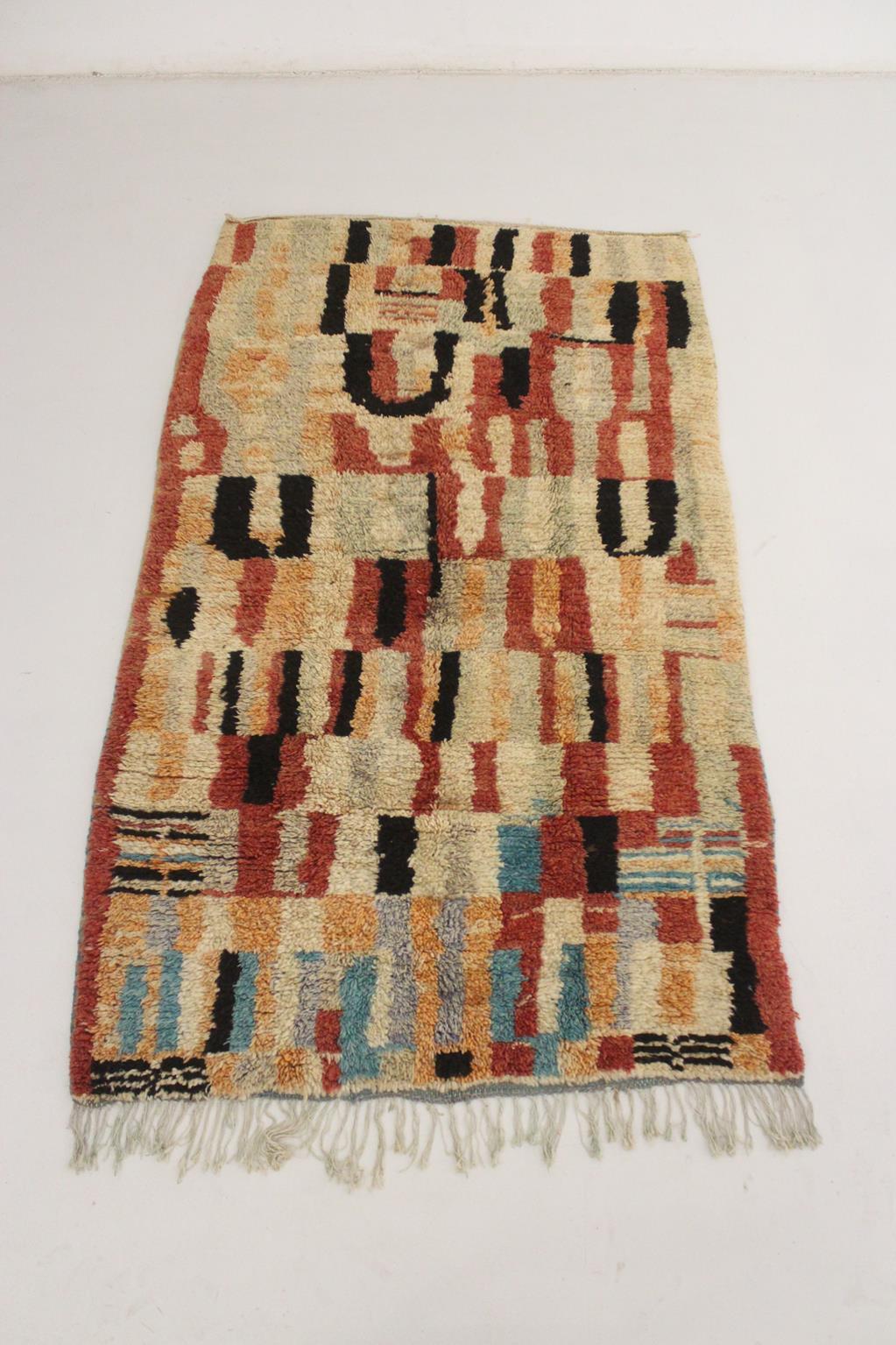 Here is one of the lovely Boujad rugs with abstract designs I fell in love with! The main colors are a terracotta mixed with black, beige, faded gray and orange and a few touches of bright blue close to the tassels ending that make all the