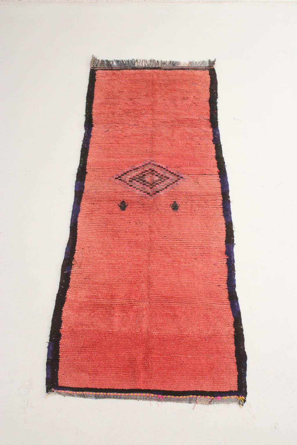 This vintage runner rug brings such a calm vibe. Probably made in the area of Boujad, Middle Atlas, Morocco, the rug is very simple as it is mostly a rich pink/raspberry background with a black and purple frame. Only one small diamond in the center,
