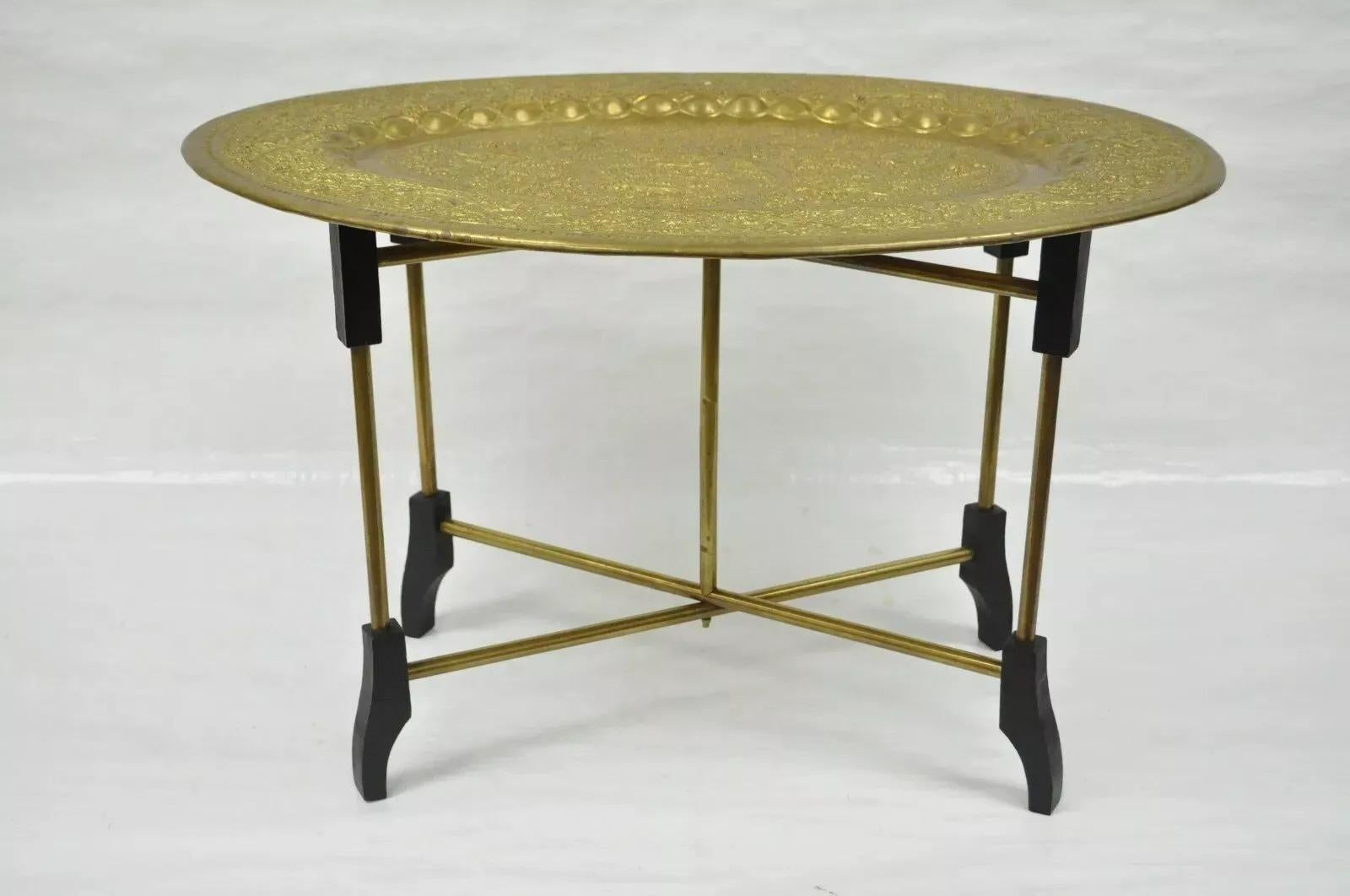 Vintage Mid Century Moroccan Brass Bird Embossed Oval Tray Folding Small Coffee Table. Item features an ornately embossed brass tray with birds and vine detailing, brass and wood x-form folding base, very nice vintage item. Mid 20th Century.
