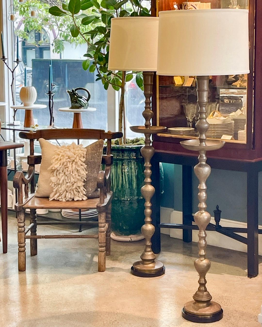 This fantastic ornamental tall vintage Moroccan brass candle holder has been up-cycled to an outstanding floor lamp. It has an intricately incised sculpted brass stem, with an ample drip tray, wood base and two light bulbs. It has been newly wired,