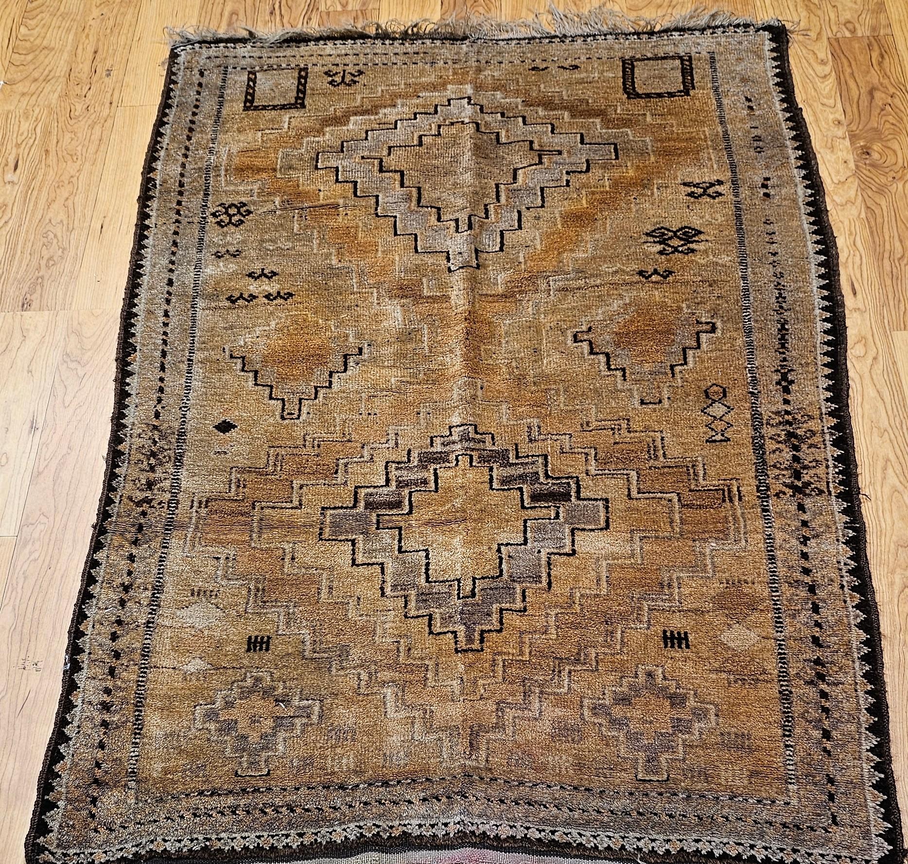 Dieser alte marokkanische Kamelhaarteppich aus dem 3. Quartal des 20. Jahrhunderts verkörpert die Schönheit der authentischen Stammesweberei. Im Mittelpunkt des Designs stehen zwei kühne Rautenmedaillons, die von kleineren geometrischen Formen