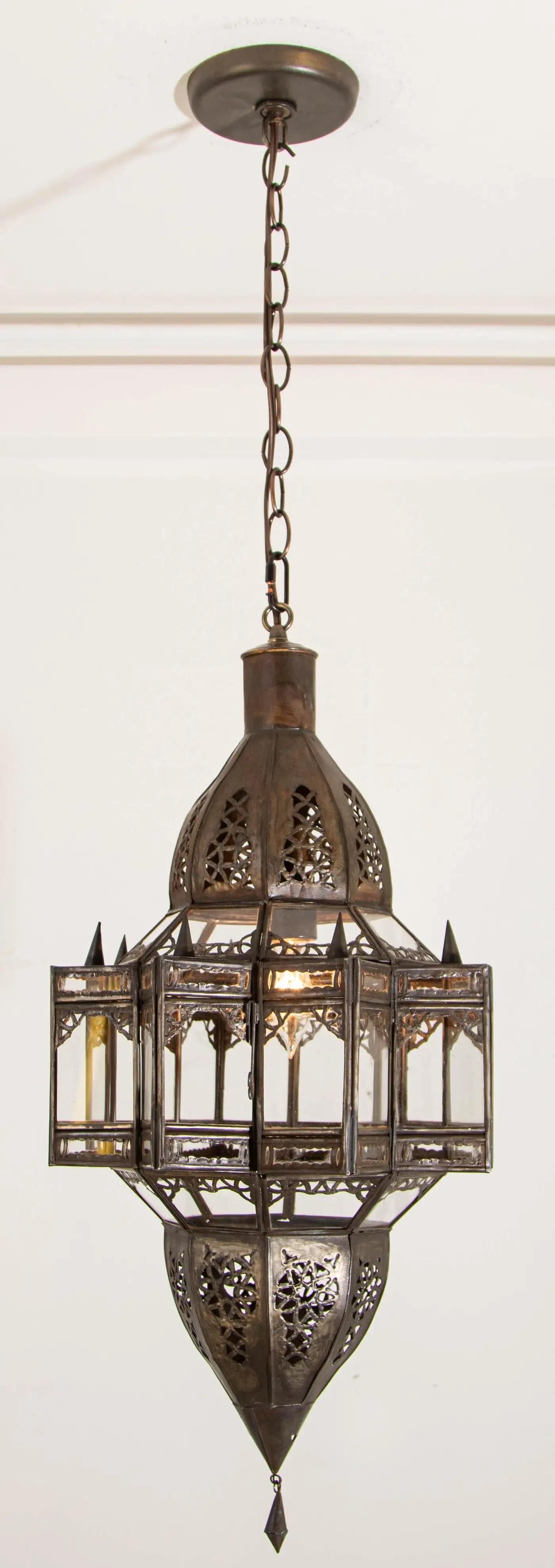 Vintage Moroccan Moorish star shape clear glass and metal lantern.
Clear Glass star shape lantern pendant handcrafted by Moroccan skilled artisans in Marrakech.
The metal is hand-cut in floral and geometric Moorish Islamic designs.
The lantern is