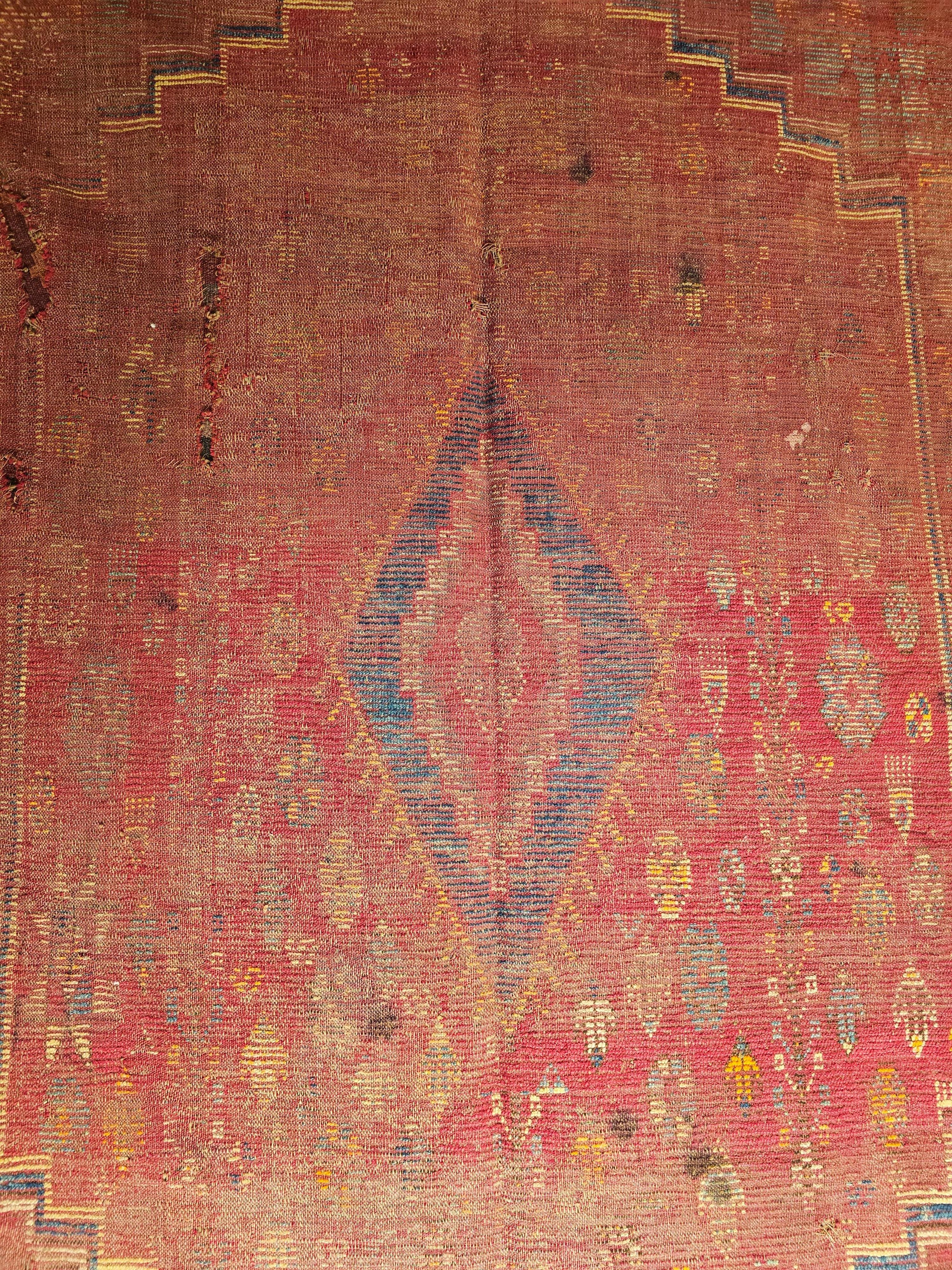 19th century Moroccan Rabat tribal carpet in a geometric pattern in a gallery/corridor size in red, yellow, turquoise, green, ivory and brown colors.  The use of vegetable dyes have produced beautiful shades in earth tone colors in the field and the