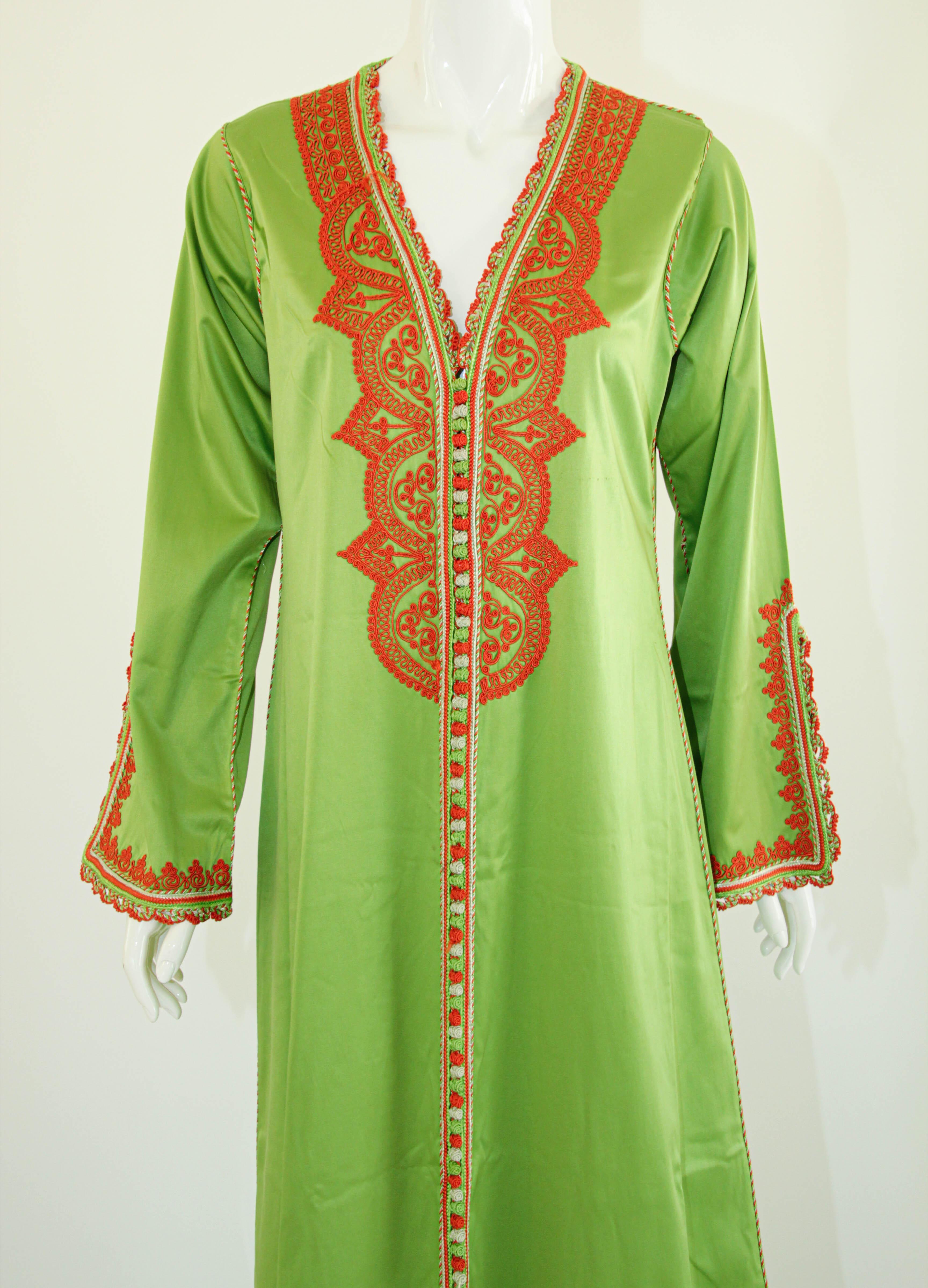 Elegant vintage Moroccan kaftan, embroidered with orange threads.
This chic Bohemian maxi dress kaftan, apple green satin is embroidered and embellished with handwoven thread trim. 
It is a slip on, the button does not open.
One of a kind custom