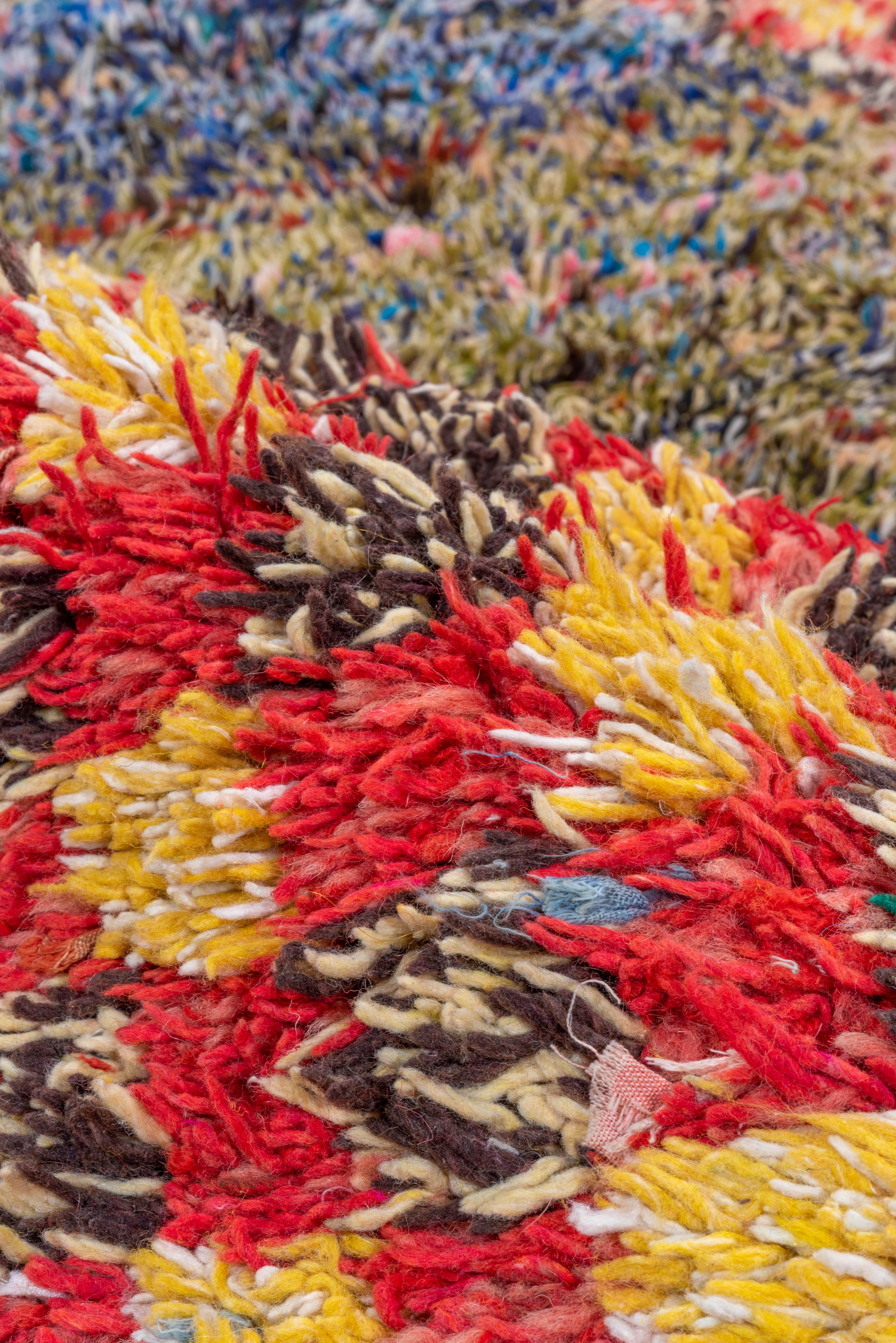 Bold and playful, this vintage Moroccan Boucherouite rug is a vibrant expression of tribal artistry, hand-knotted using repurposed textiles in the traditional Berber manner. Its rich checkerboard composition in saturated crimson and soft cream forms
