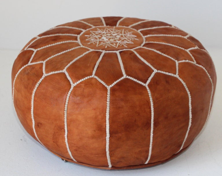 Vintage Moroccan handcrafted brown camel leather ottoman, with embroideries.
Could be used a foot stool, or side table or ottoman.
The Moroccan leather poufs are hand-tooled and embroidered with white tread.
Very nice handmade vintage Moroccan
