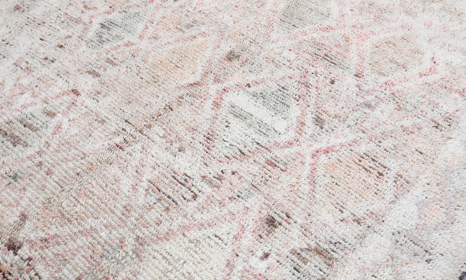 This vintage Moroccan hand knotted wool rug is hand-carded with all natural dyes in beige and pale pink colors. Selectively curated from thousands of pieces, our Moroccan collection represents the most unique styles from the Atlas Mountain region.