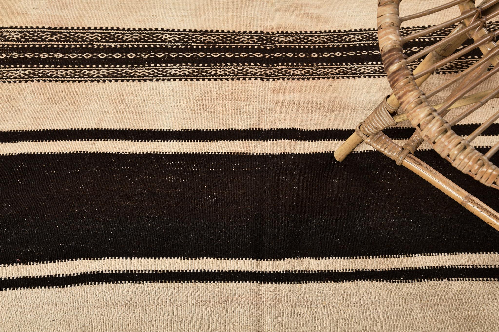 Near-square flatweave piece in alternating bands of natural brown and ivory with pattern elaborations at center and edges.  A unique vintage tribal rug from the Atlas Mountains of Morocco.