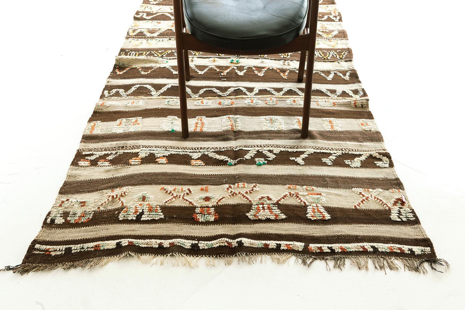 Banded flatweave in alternating natural brown and ivory with rows of repeat motifs rendered in ivory, brick-red and sage green knotted pile. An intriguing combination of textures. This is a unique vintage tribal rug from the Atlas Mountains of