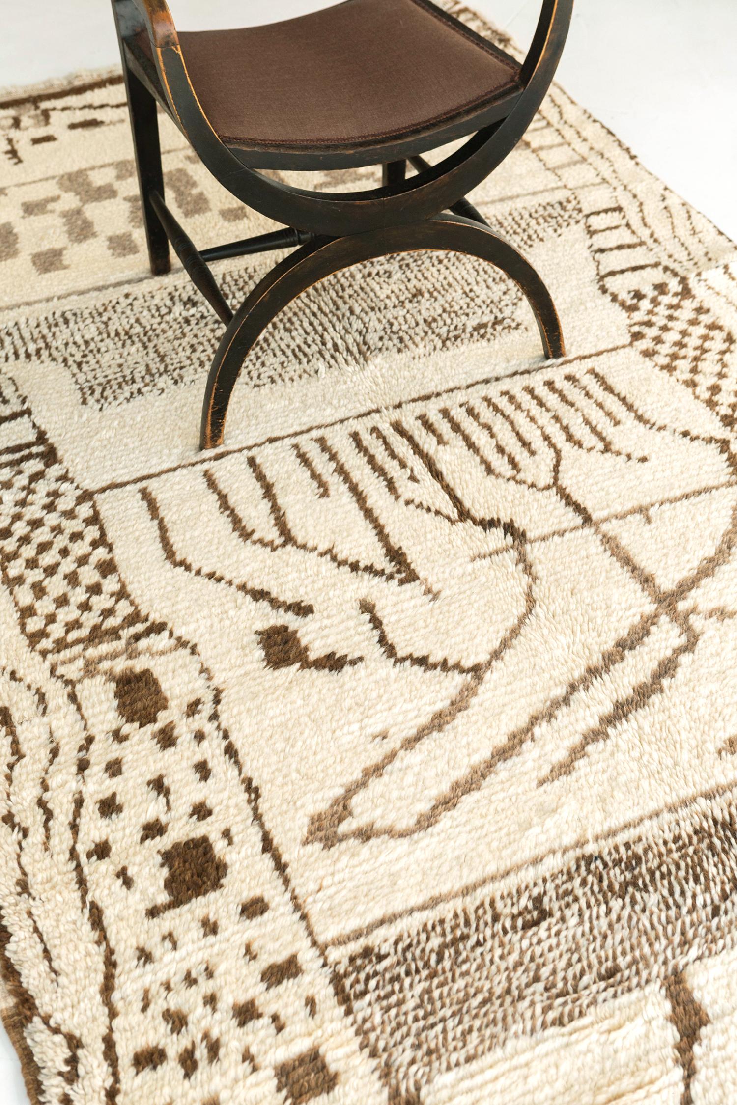 A Vintage Moroccan High Atlas Tribe rug that features signifying elements woven into this majestic rug. It boasts a series of ambiguous motifs that form together and and made a perfectly matched collaborative effect running along the of the plush