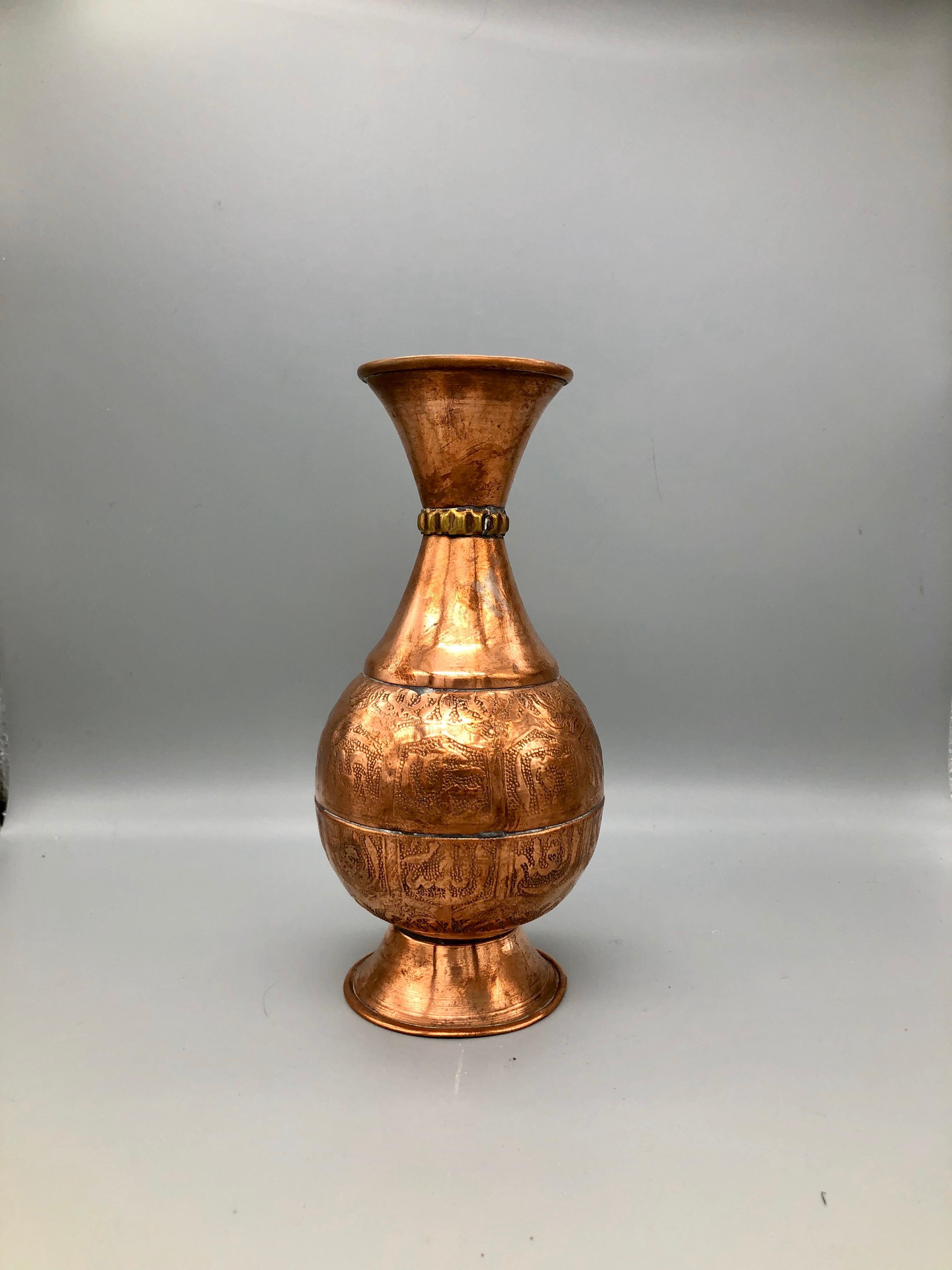 This shiny red copper Moroccan vase is specially reserved for Eid celebrations. Delicately hammered, the vase has a stippled effect, with raised Arabic repousse lettering. The vase has five distinct parts that have been permanently welded, with a