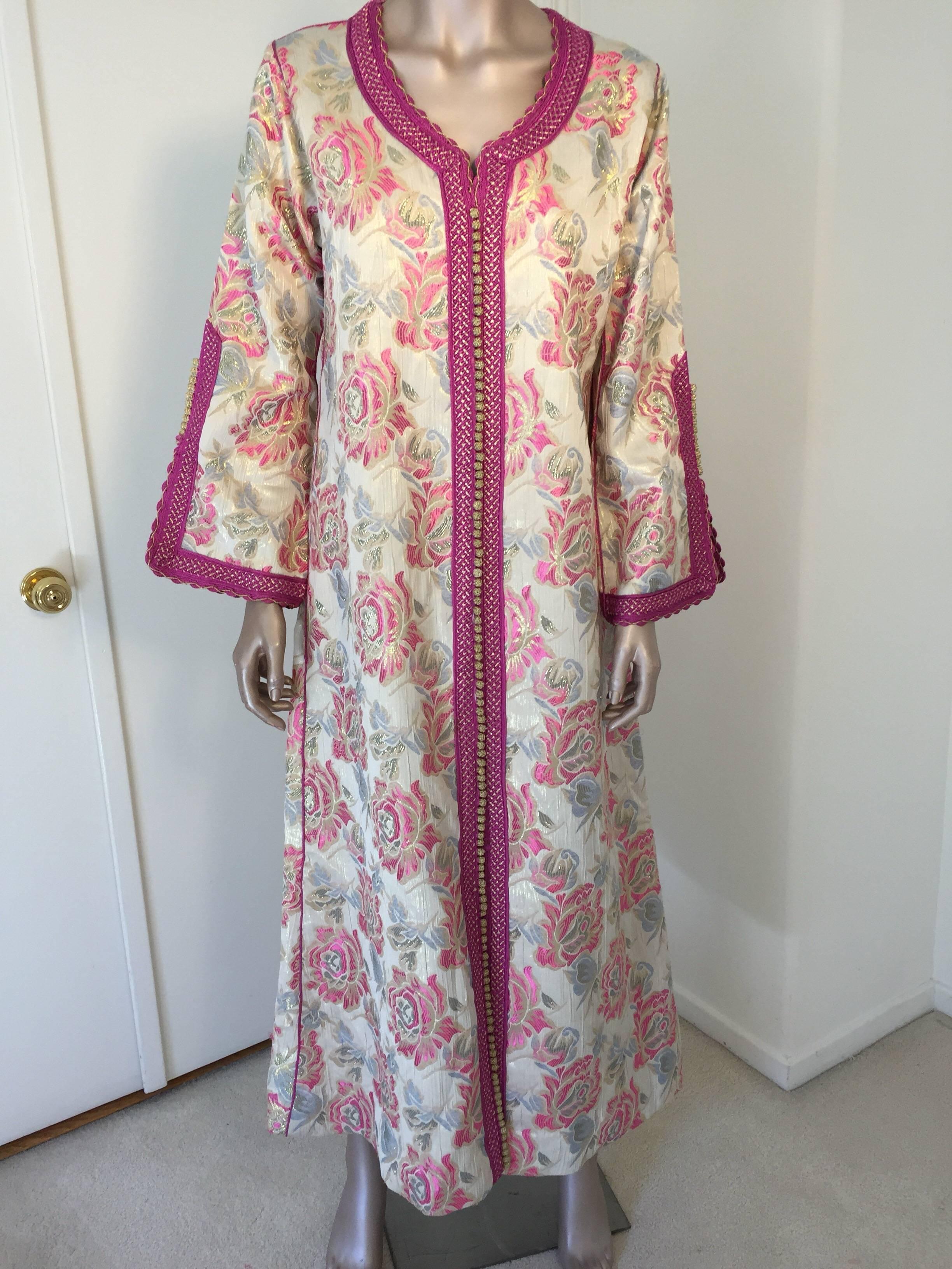 Elegant vintage designer Moroccan caftan, floral brocade embroidered with hot pink and gold trim.
This chic Bohemian maxi dress kaftan is embroidered and embellished with gold and pink thread metallic trim. 
One of a kind evening Moroccan Middle