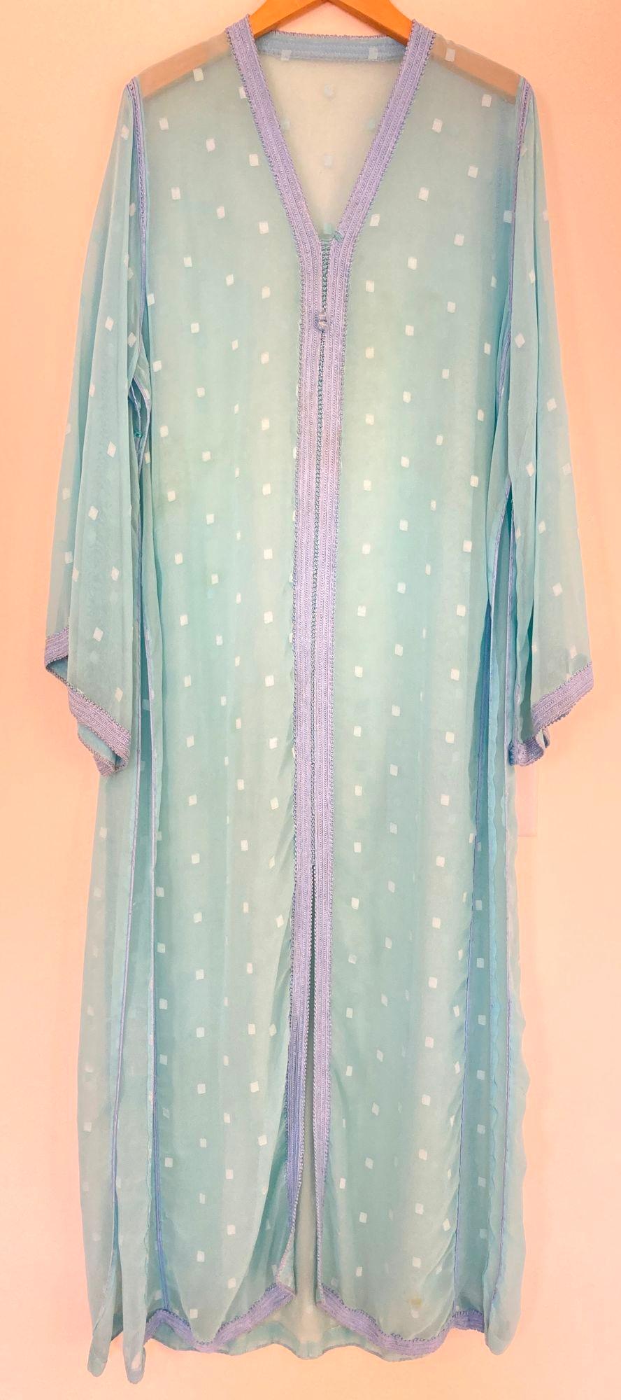 Elegant Moroccan caftan in turquoise cheer fabric and hand braided embroidered trim,
circa 1970s.
This long maxi dress kaftan is embellished entirely by hand.
It’s crafted in Morocco and tailored for a relaxed fit.
One of a kind Moroccan caftan.
The