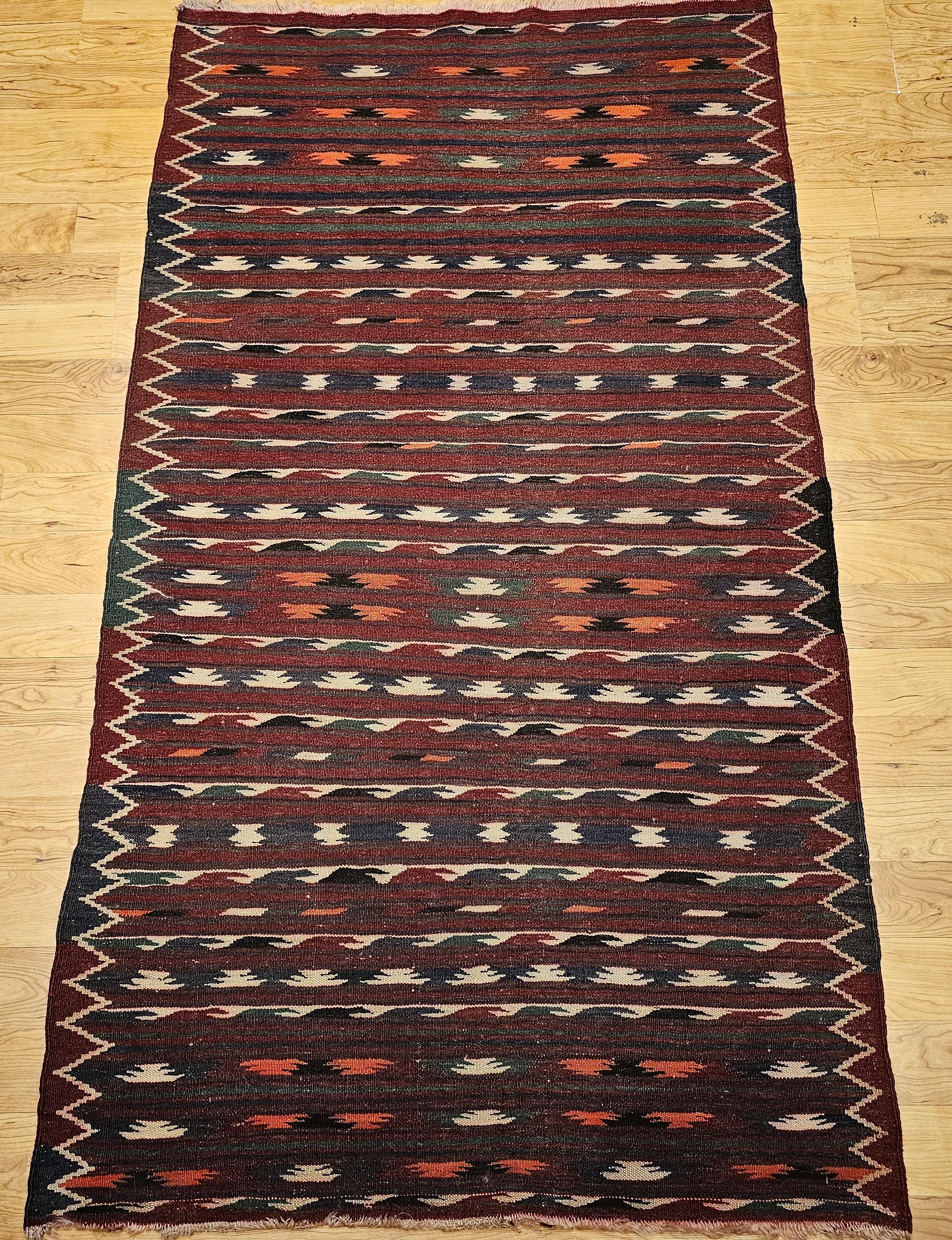 Apportez un caractère audacieux et une touche artistique intemporelle à votre intérieur avec ce tapis kilim marocain vintage, tissé à la main au milieu des années 1900. Ce tapis à tissage plat, qui présente une étonnante gamme de motifs