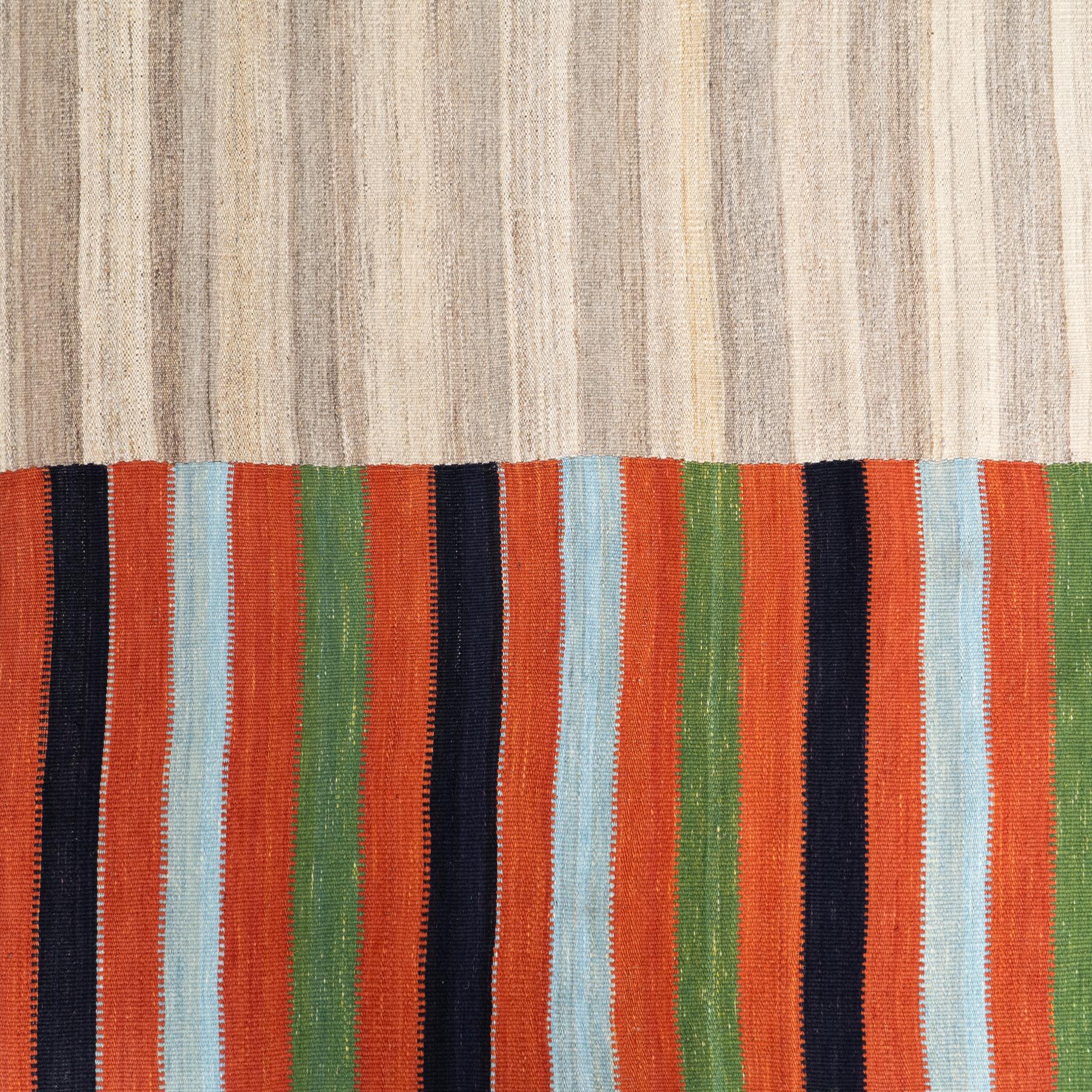 This exceptional vintage Kilim rug, handwoven around the 1970s, features a captivating divided design, offering two distinct styles in one piece. Measuring 106 x 169 cm, this rug showcases a rationalist, geometric pattern in soft earth beige tones