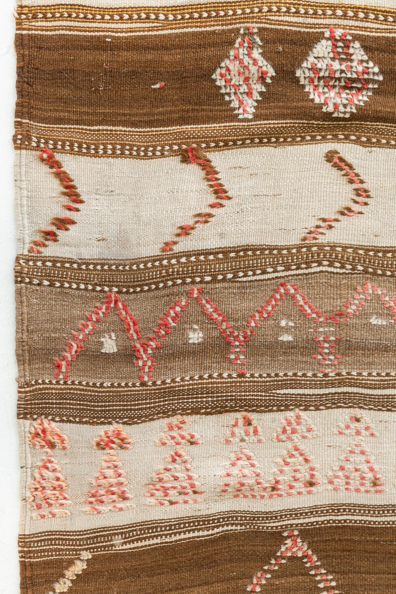 A fashioned Moroccan Kilim rug in an embossed symbols makes your space more feminine. Diamonds are in subtle pink tone and well incorporate with fringes and tassels. It looks good beside to your dresser or to your floor cover layer walk-in