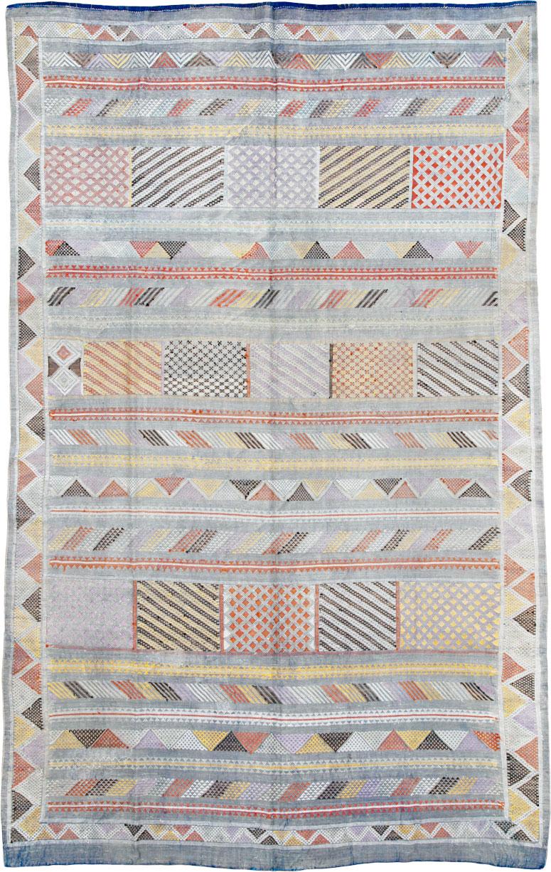 A vintage Moroccan Folk Kilim flatweave from the late 20th century. Slate blue, yellow, red, black, and white are among the hues on this pileless flat Moroccan tribal carpet-textile with a pattern of large, dotted, and diagonally striped rectangles