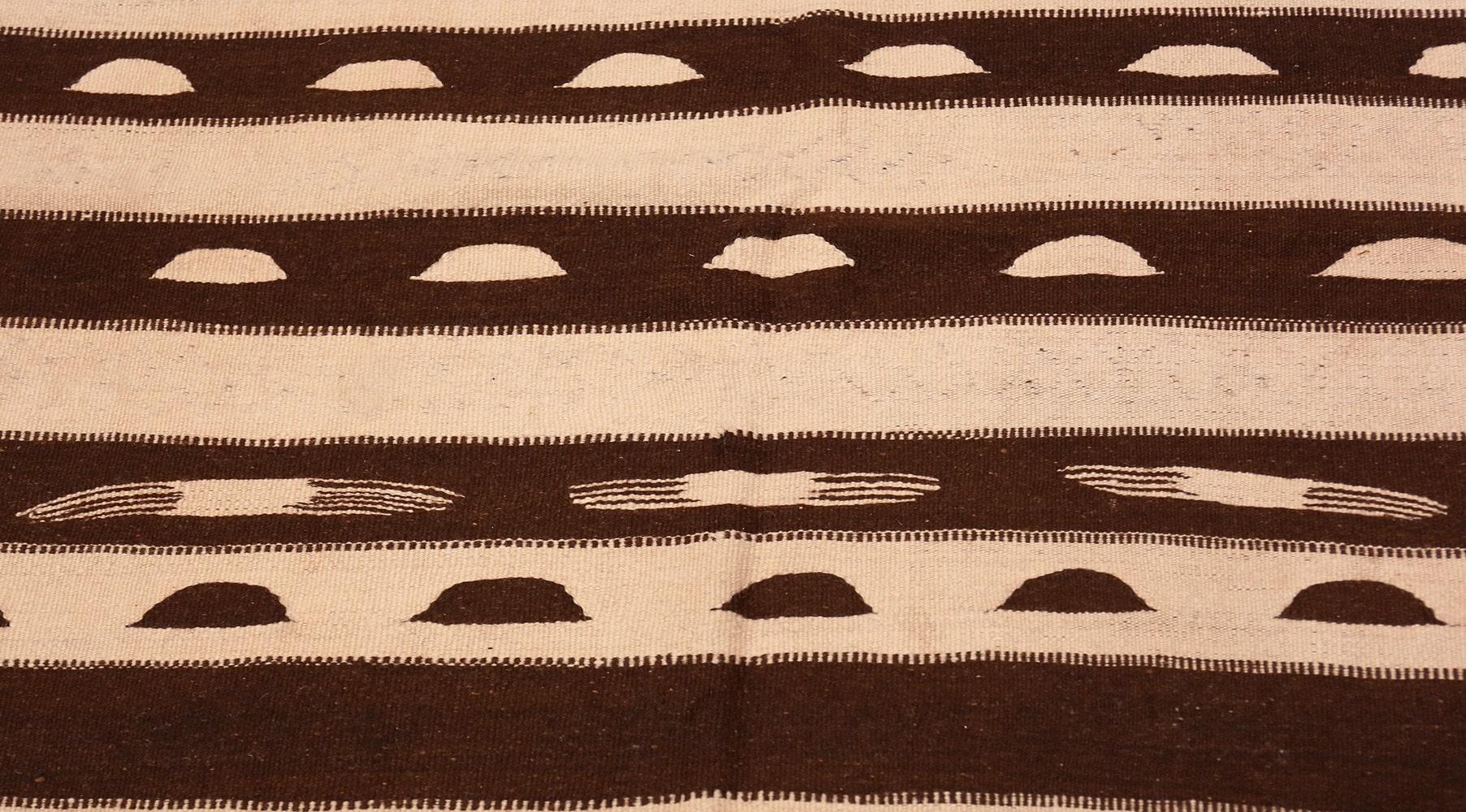 Beautiful brown and cream flat-woven vintage Moroccan Kilim rug, country of origin: Morocco, date: circa mid-20th century. Size: 4 ft 7 in x 9 ft 8 in (1.4 m x 2.95 m)

This cleverly composed vintage flat-weave Moroccan Kilim rug features an