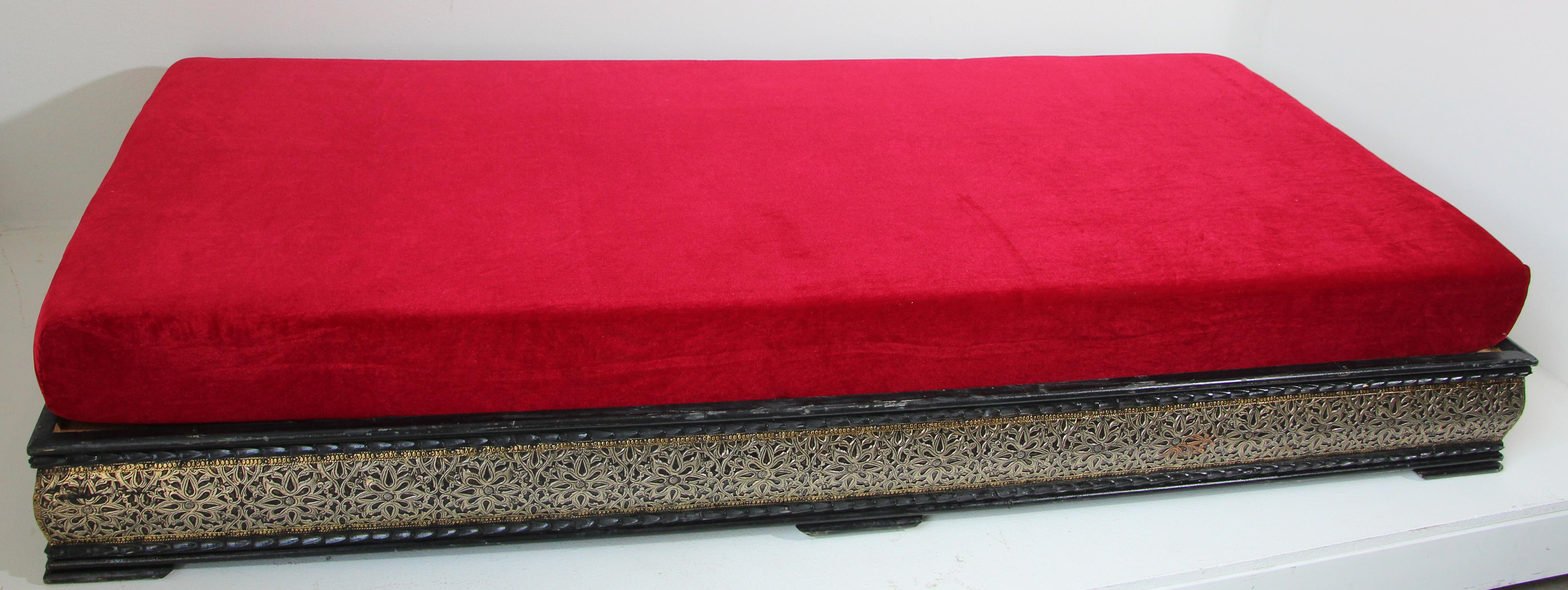 Vintage Moroccan low bench, day bed.
Traditional Moroccan sofa, low bench handcrafted in a wooden base adorned with silvered metal with traditional geometric design, top cushion foam covered with a red velvet fabric.
Moroccan upholstered settee,