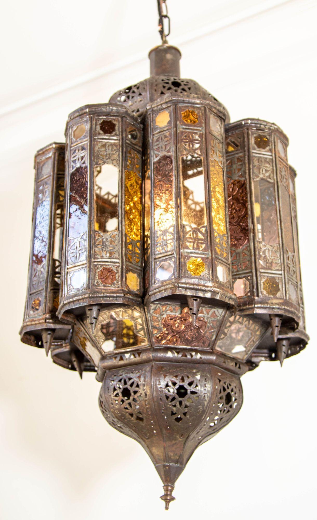 Vintage Moroccan Mamounia Moorish clear glass and multicolor lantern.
Large Moroccan patinated metal and glass lantern, ceiling light Moorish pendant lantern.
Multicolor glass, amber, lavender and clear, multifaceted and intricate filigree Moorish