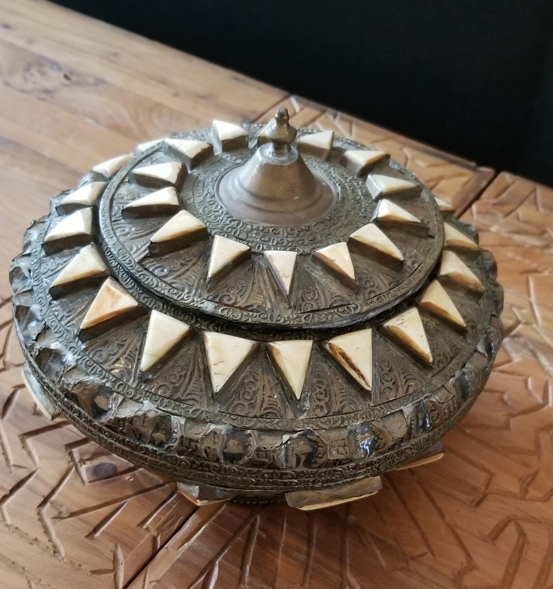 In remarkable condition.
Made from metal and inlaid with camel bone fragments, this beautiful Moroccan tobacco / spice box is a few decades old, and has a few signs of signs of wear and tear. Great for decoration with its amazing patterns