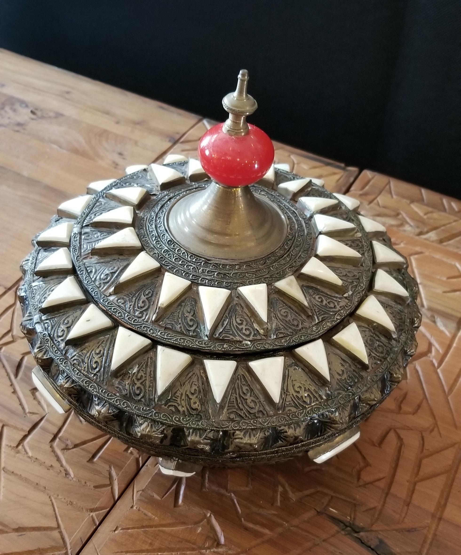 In remarkable condition.
Made from metal and inlaid with camel bone fragments, this beautiful Moroccan tobacco / spice box is a few decades old, and has a few signs of signs of wear and tear. Great for decoration with its amazing patterns