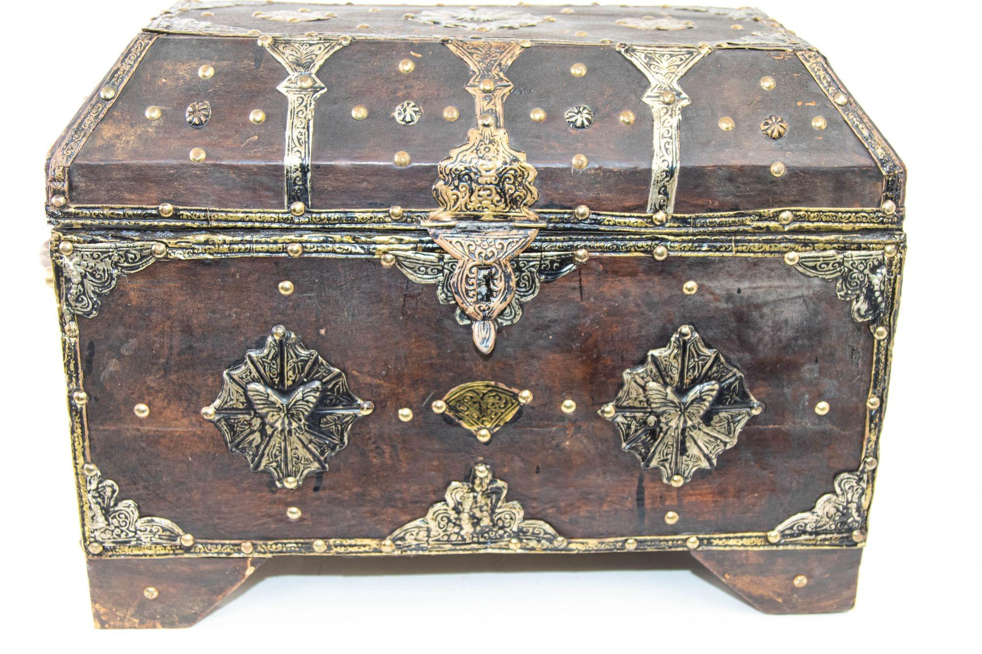 Vintage Moroccan dowry trunk with an angular dome top, the wood has been covered in leather on all sides.
Adorning the leather surface are intricate brass decorations that add a touch of opulence and visual interest. The brass designs are