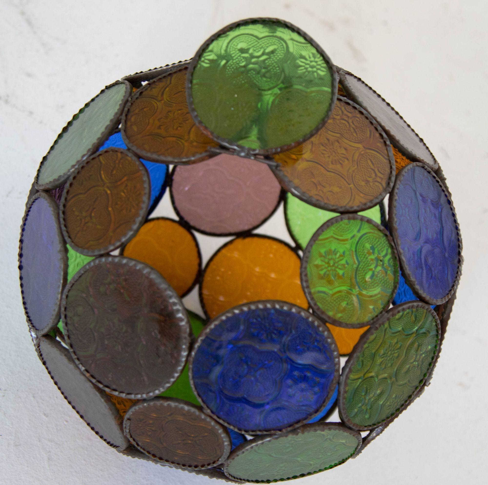 Handgefertigte mehrfarbige marokkanische Glaslaterne oder maurische Pendelleuchte im Vintage-Stil.
Mehrfarbiges gegossenes Glas in Blau, Grün, Lavendel und Bernstein mit maurischen Kreisen, die in einer Lampe im Orb-Stil vereint sind. Handgefertigt