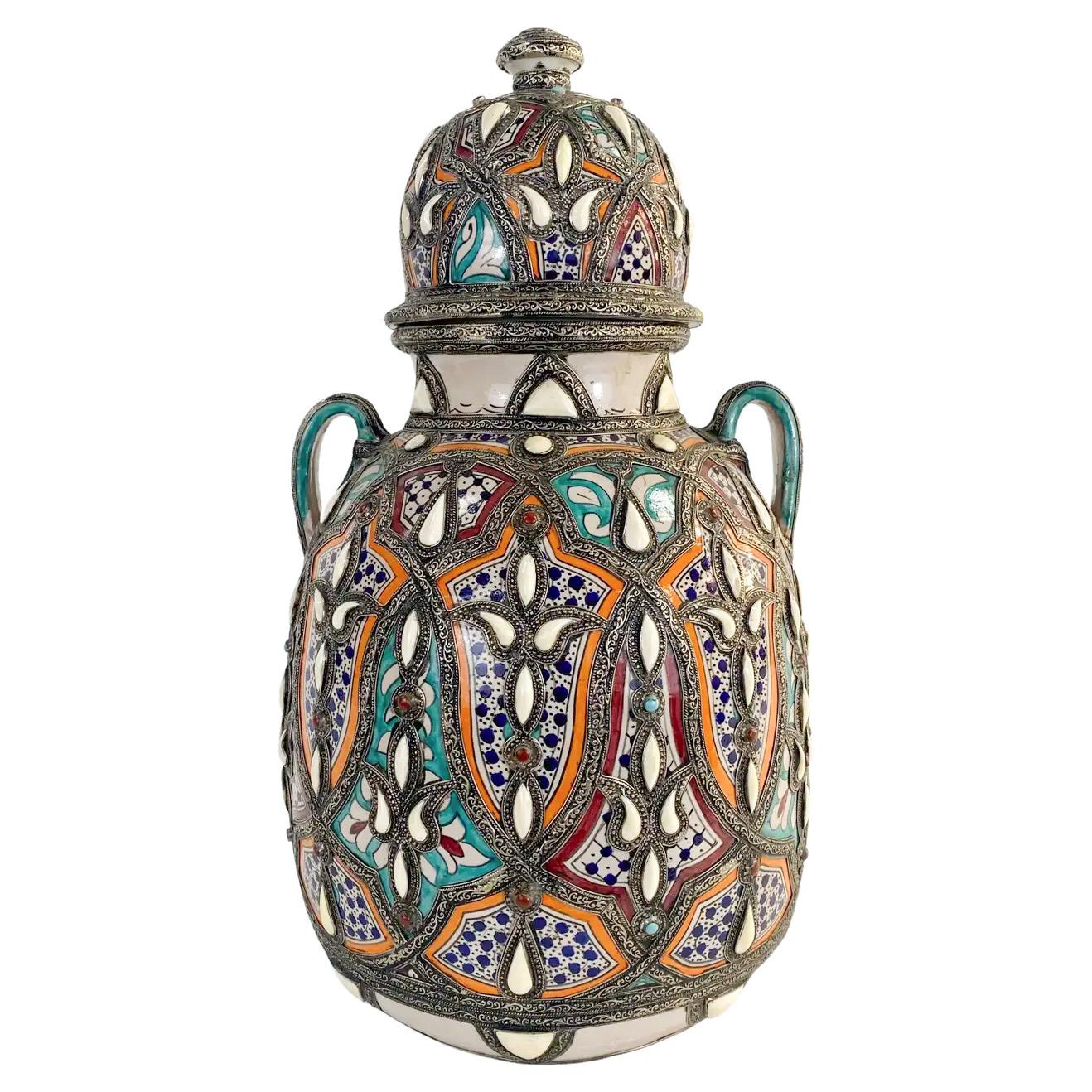 A pair of 1970's Moroccan hand made palatial lidded vases with an entrancing and elaborate design scheme, brass frame and the sculptural grace that only master artisans can provide, this large vase is a statement-worthy addition to any living space.