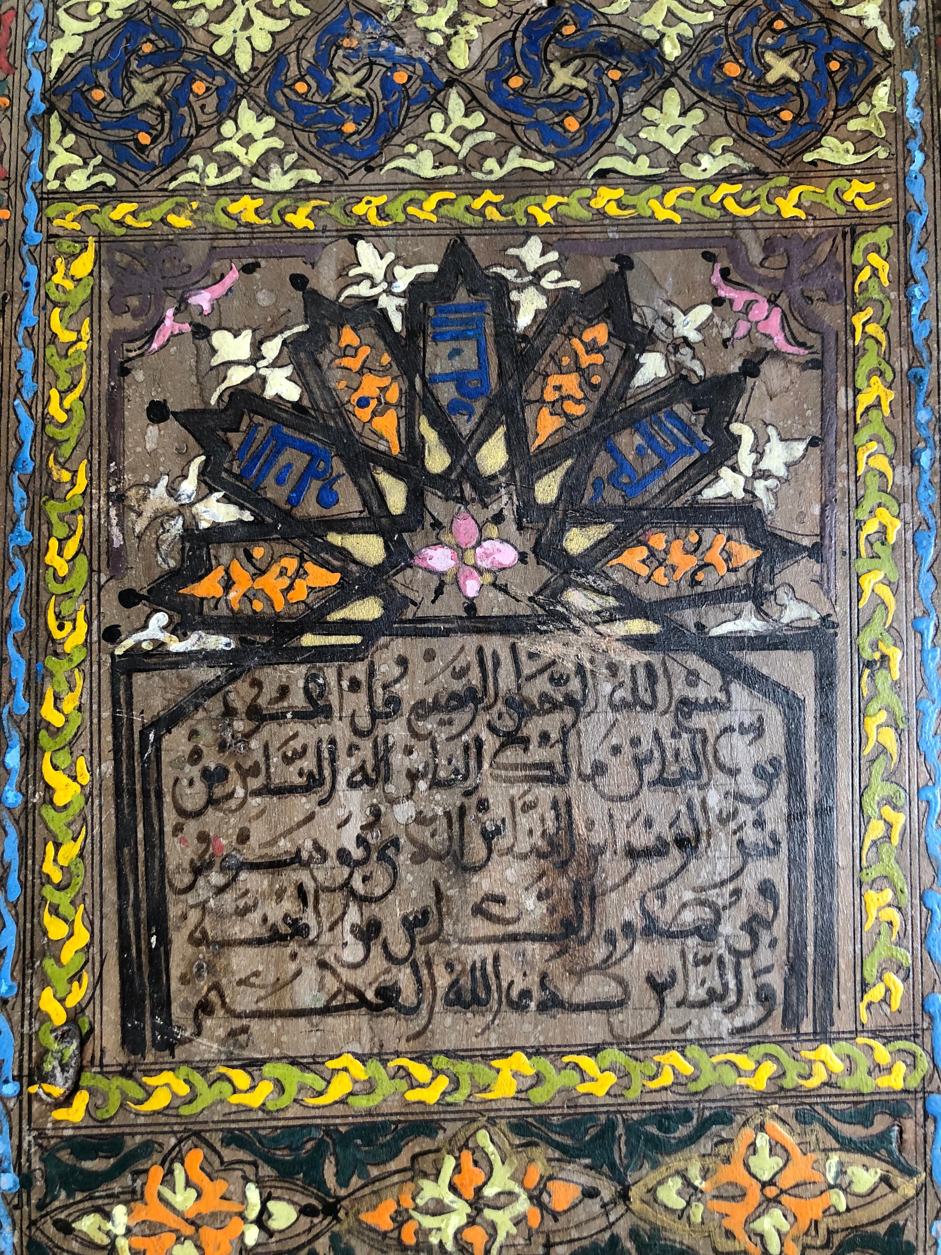 Vintage hand-painted hardwood tablet inscribed with verse from the Holy Quran. This tablet is circa early to mid 20th-century and is from the southern Moroccan desert town of Zagora. Used in schools to teach the Quran, students between the ages of