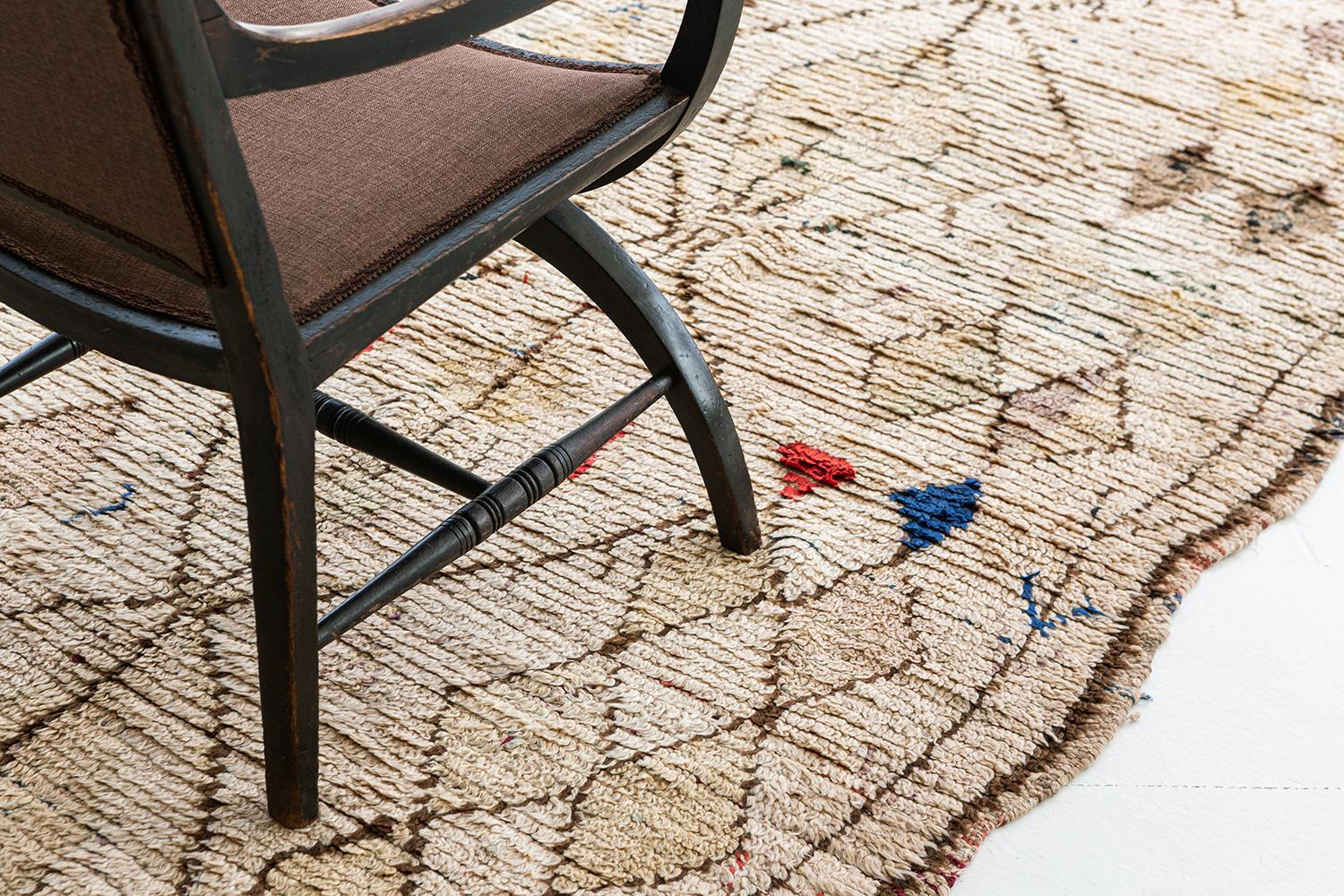 A unique design of Moroccan rug Azilal Tribal design that stands-out with any other rugs and makes it extraordinary. It features scissors and lozenges with extended sides with the color combinations of pastel and bright red and blue hues in an ivory