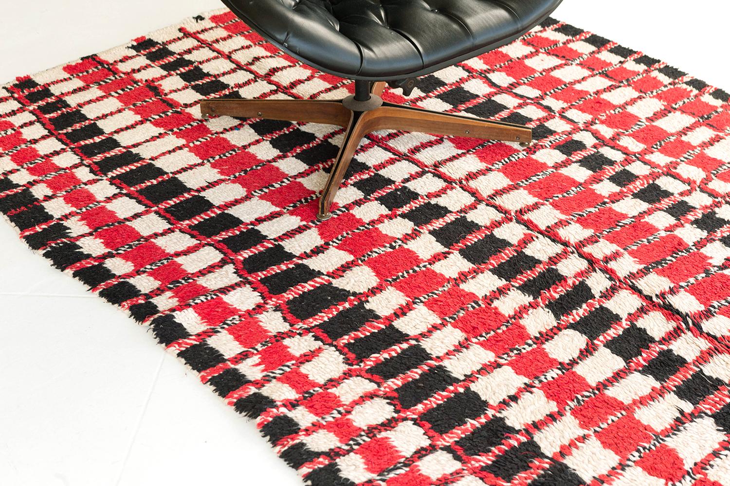 A magnificent vintage Moroccan rug of Azilal Tribe in Atlas Collection that features the stunning tones of ivory, charcoal and salmon red. A high-impact irregular sized checkerboard pattern decorates the field that was resulted from the