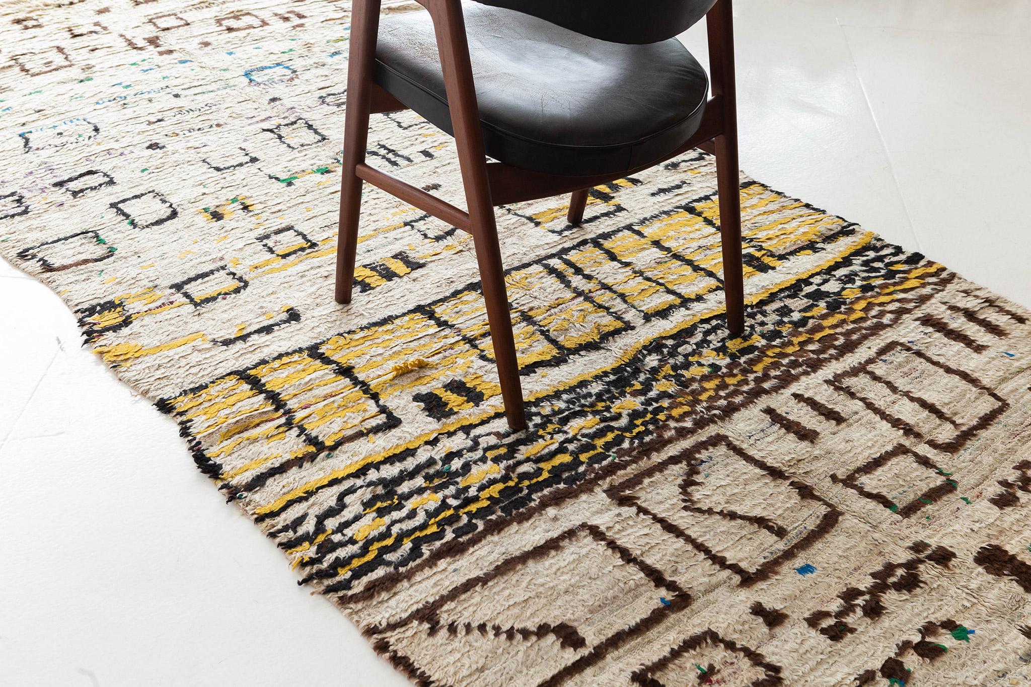 Ivory field with rectilinear motifs in dark brown with yellow and aqua elements in orderly banded arrangement and shifts in scale between top and bottom registers.  A unique vintage tribal piece from the Atlas Mountains of Morocco. 