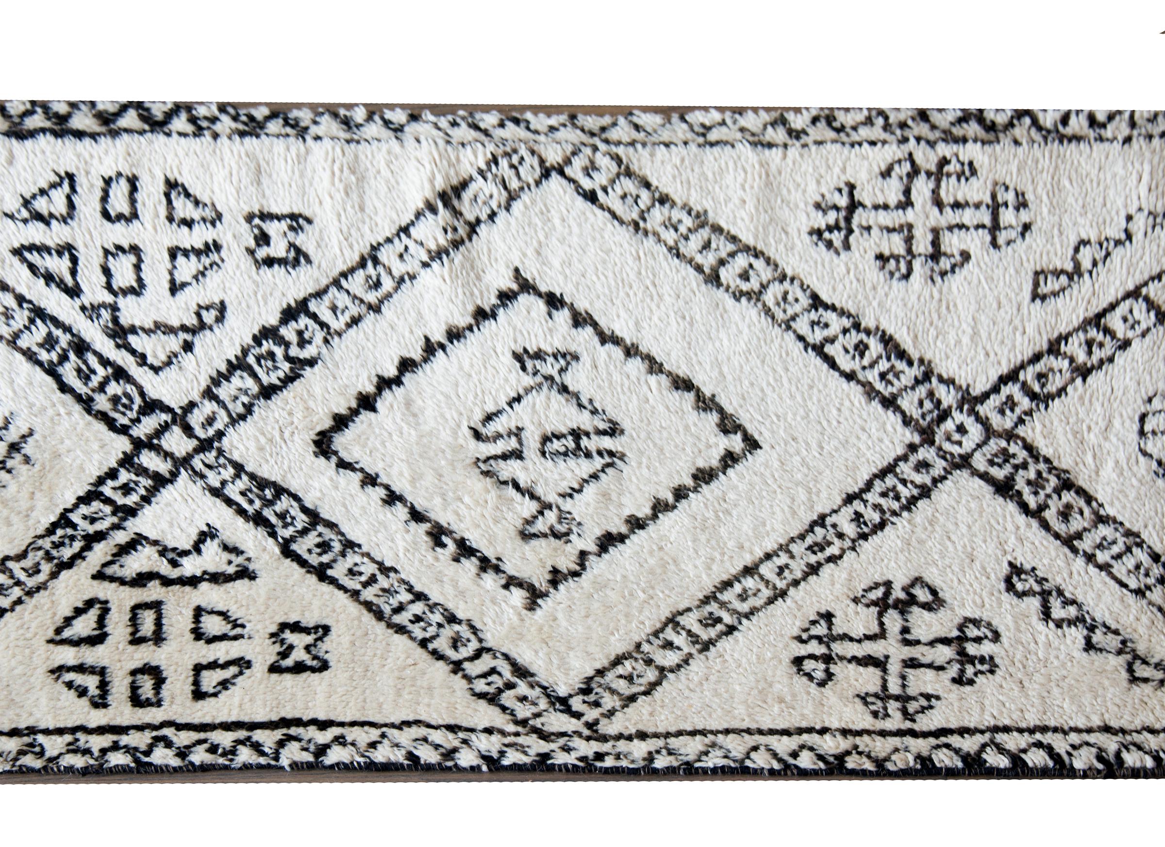 Magnifique tapis marocain du milieu du 20e siècle, tissé en laine blanche et brune, avec un motif moderne audacieux contenant de grands zigzags avec des motifs floraux stylisés mélangés.