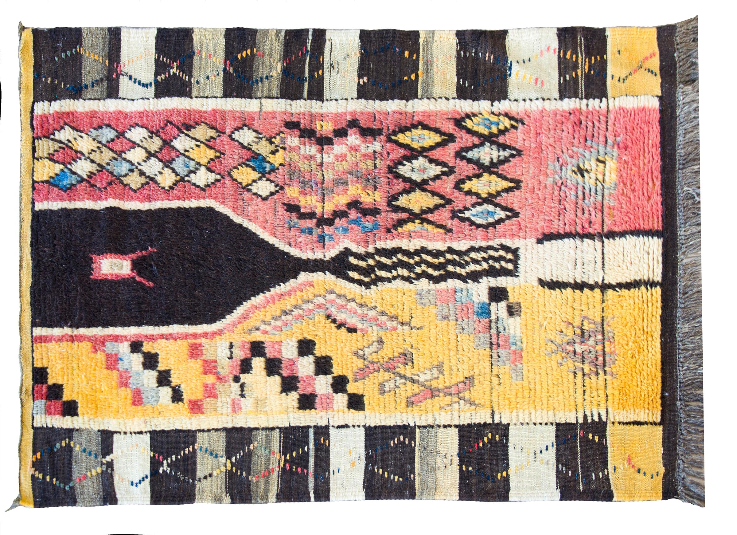 A wonderful mid-20th century Moroccan rug with a beautiful modernist pattern with multi-colored diamonds and stylized flowers, with a fantastic black and white striped border.