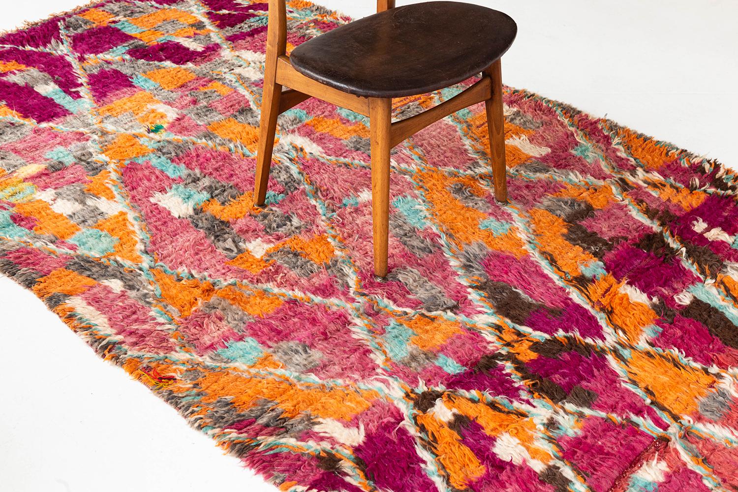 A bold a lively vintage Moroccan from the High Atlas tribes of Morocco. This rug's saturated and cohesive colors makes for the perfect vintage piece. Handwoven tribal elements and symbolic designs add to the rug's uniqueness and overall