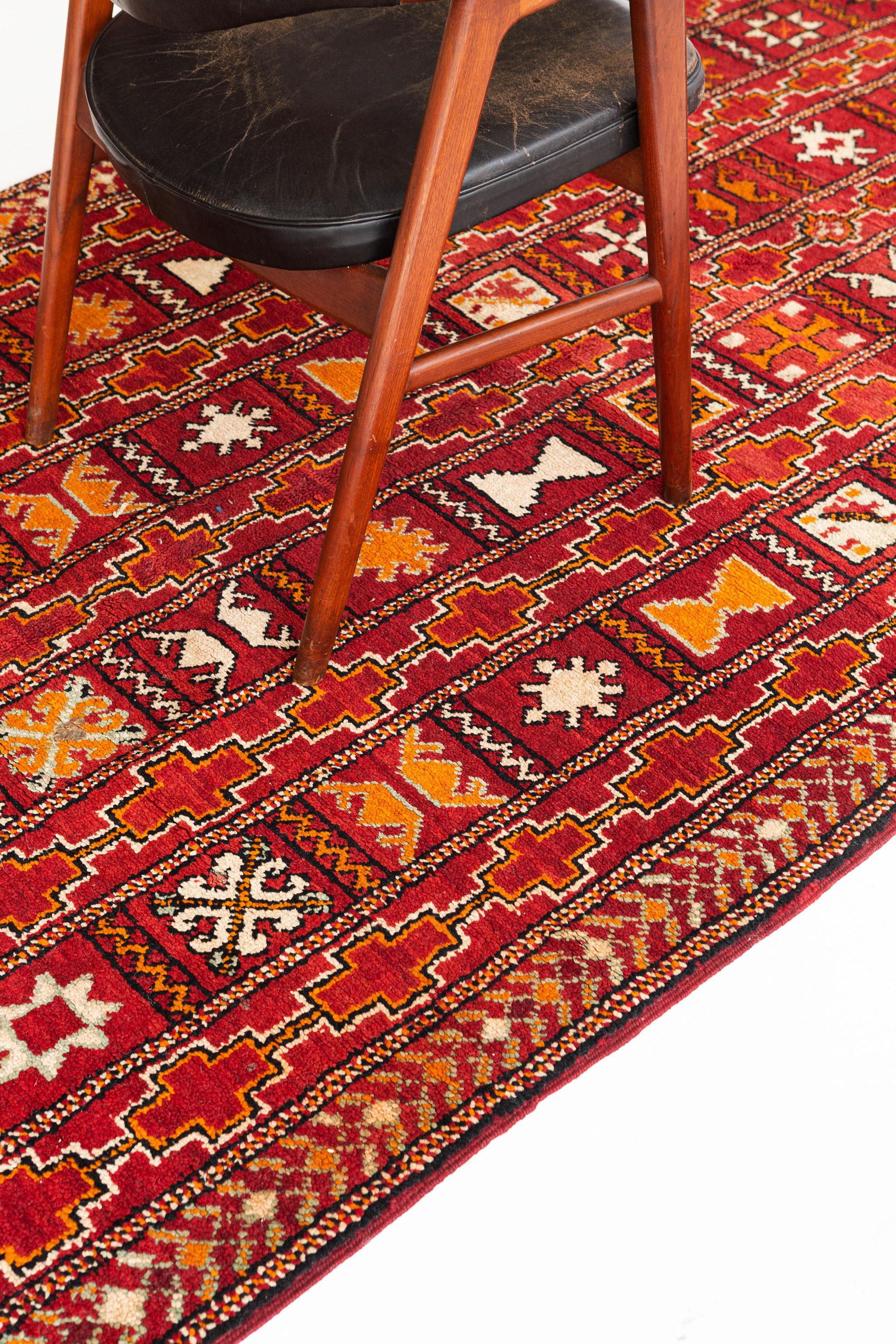 Bold ruby red field with rows and columns of expertly rendered motifs in orange, black, ivory, and pale gray-green. This is a fine vintage tribal piece from the High Atlas Mountains of Morocco.