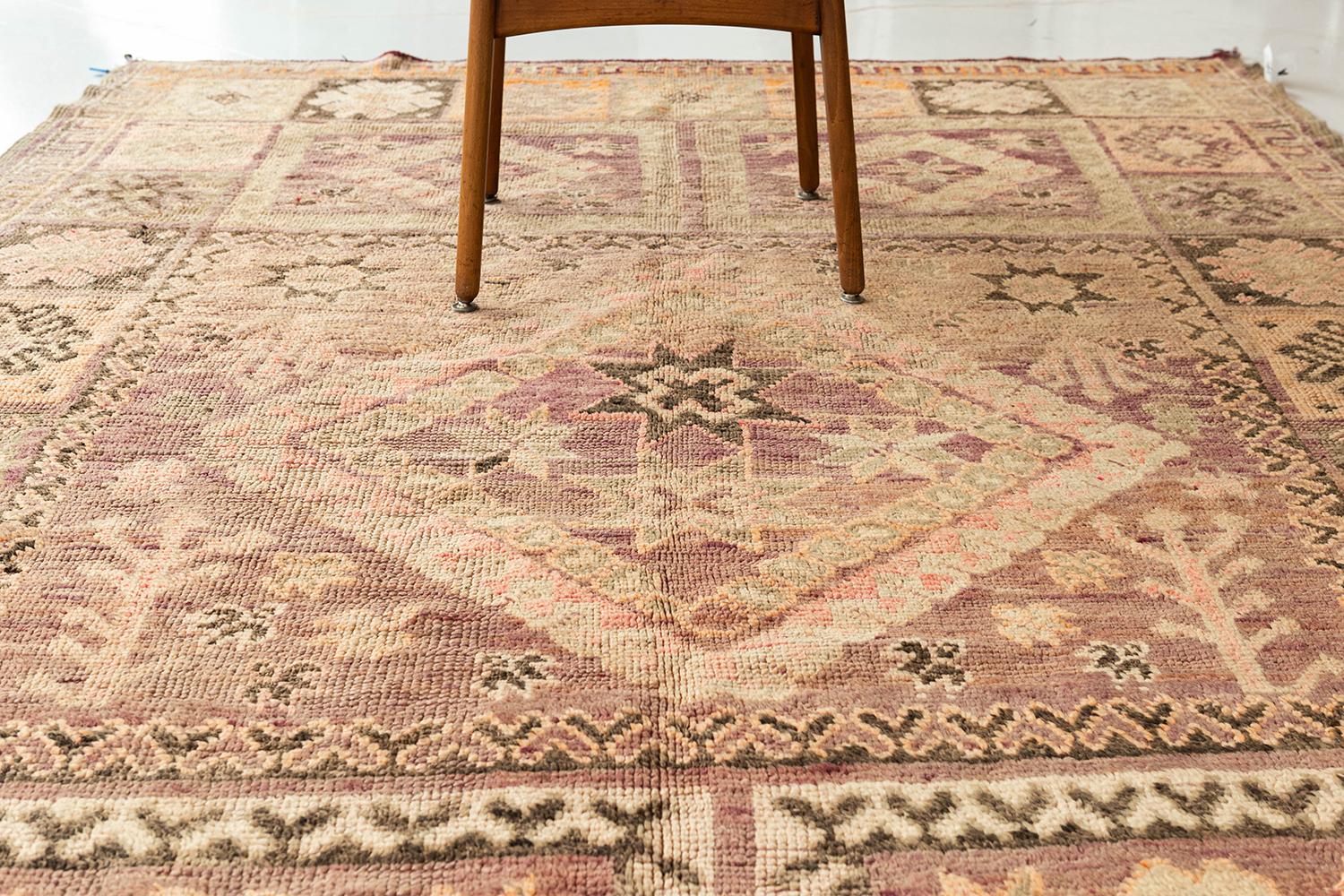 A unique and charming antique tribal rug from the High Atlas Mountains of Morocco. This beautiful piece has rich colors and is designed with symbolic diamonds and geometric shapes commonly found in High Atlas tribal rugs. This piece will bring an