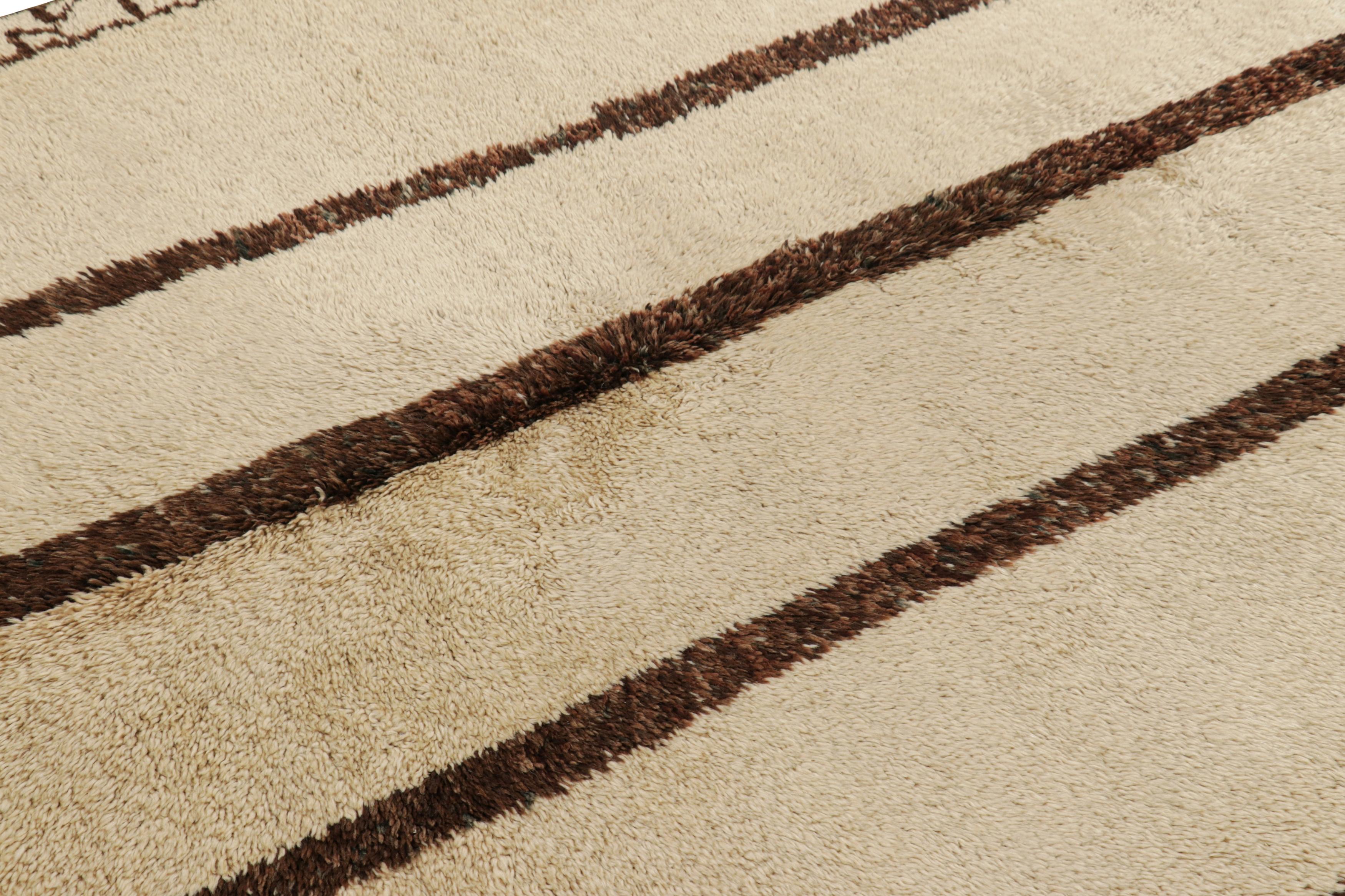 Hand-knotted in wool and originating from Morocco circa 1950-1960 and possibly older, this 6x7 vintage Moroccan striped rug in beige and chocolate brown, is an extremely rare piece like so few of its provenance.

On the Design: 

Admirers of the